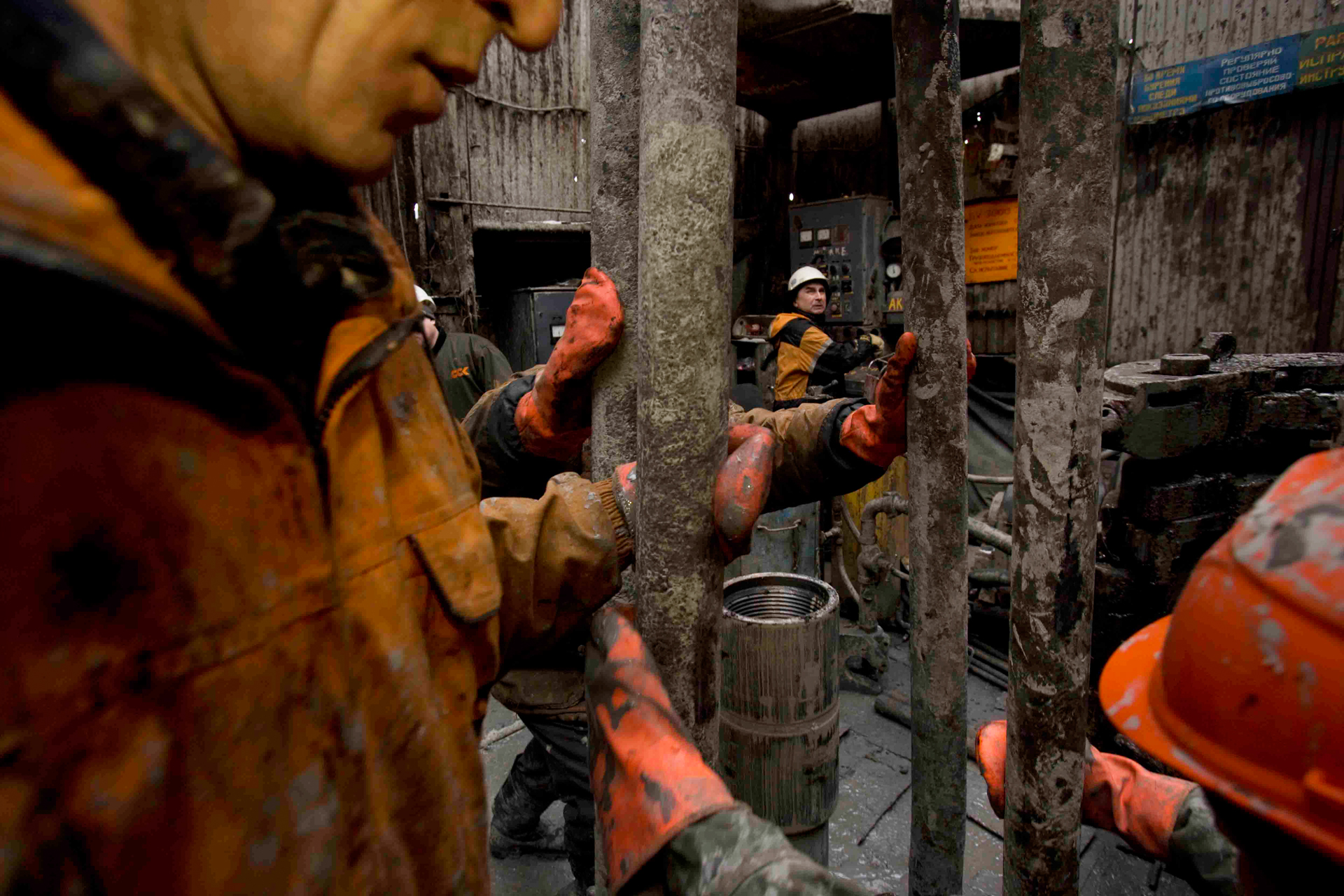  Mud-spattered and cold, oil workers change a drilling pipe. The enormous growth of Russia's oil industry has been fueled by surging world oil prices.  Yuzhno-Priobskoye, Russia  