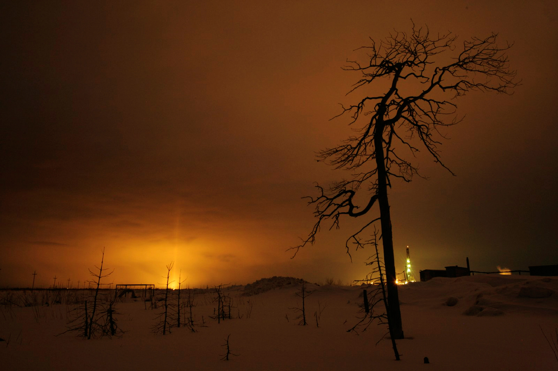  Gas flares and rig lights sear the night sky. Russia is now the world's top producer of crude oil.  Savuiskoye oil field, Russia  