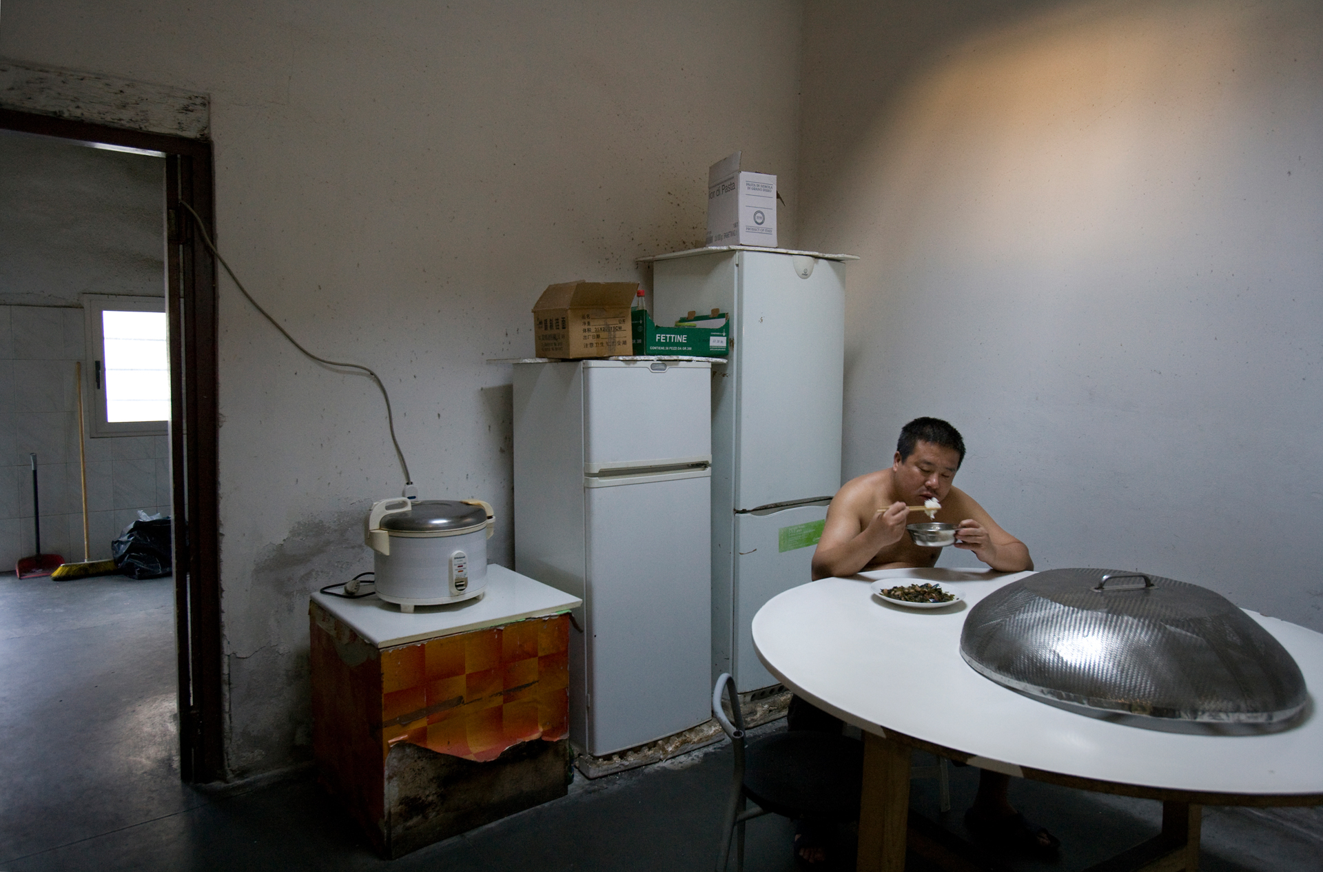  A Chinese laborer takes a break from the textile factory floor for a brief meal before returning to work. 