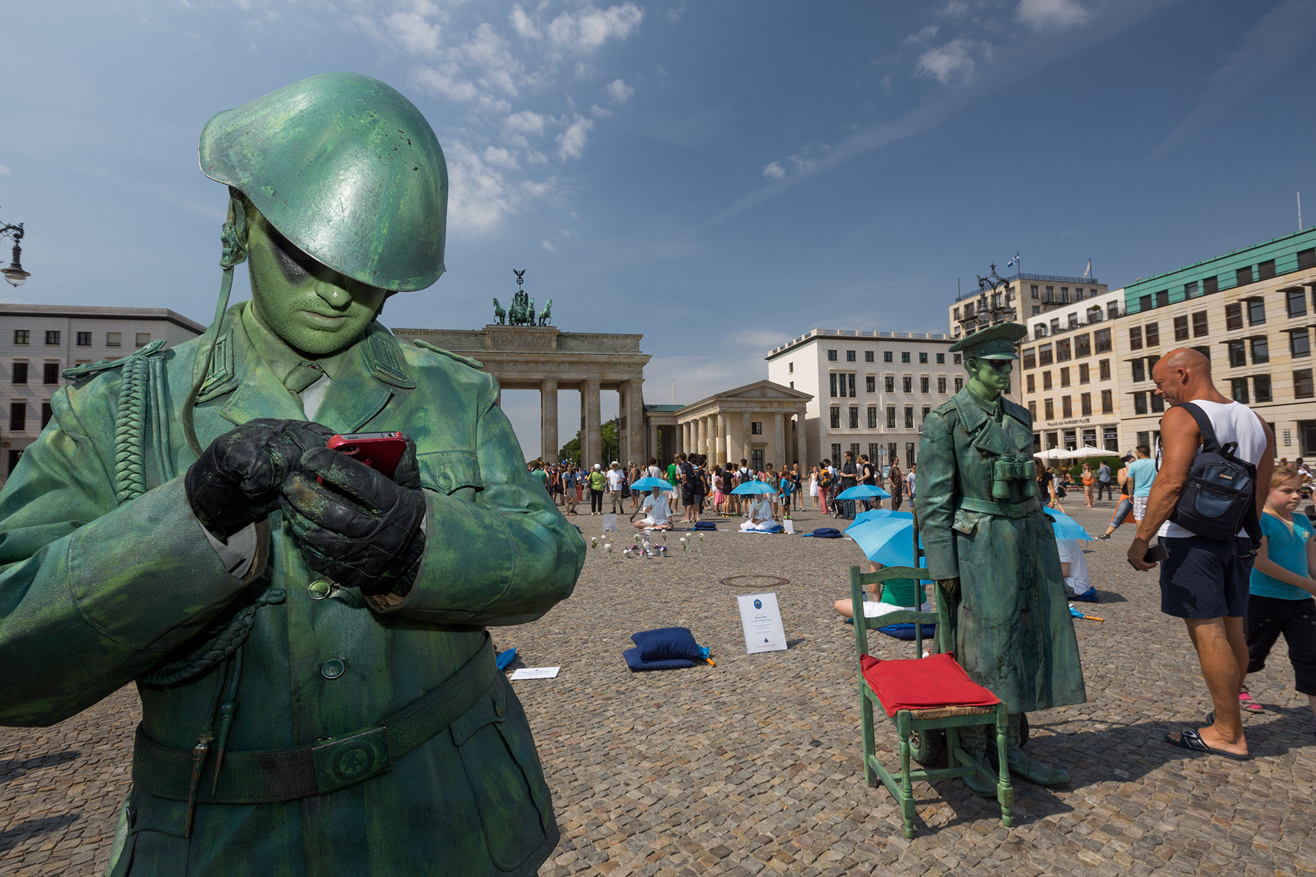  A Slovakian street artist poses as an East German border guard in front of the Brandenburg Gate.  Berlin, Germany.  
