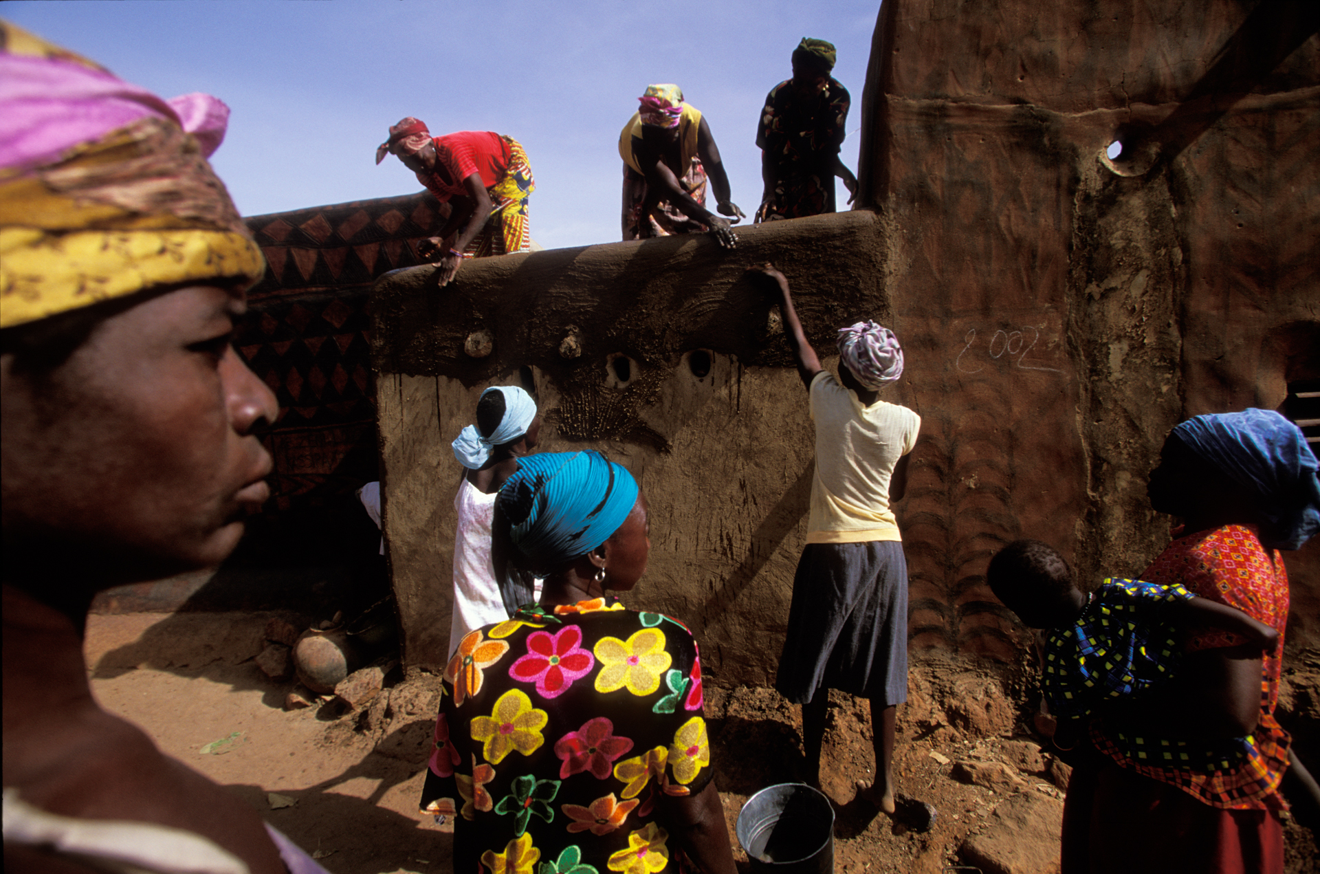  Once a year, during the annual art and culture festival, houses are repainted with beautiful designs. Women first coat the compound’s walls with a fresh layer of clay before painting.  Tiebélé, Burkina Faso  