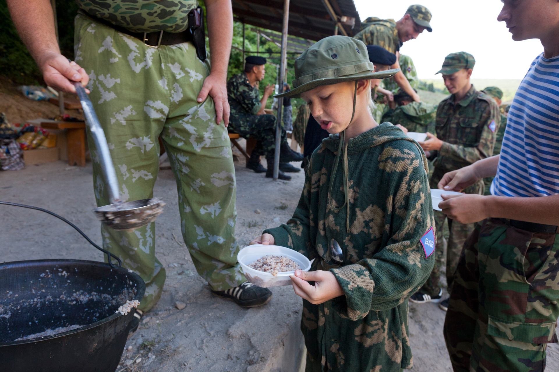  A young attendee frowns over the bland meal offered at the Cossack camp.  Eski-Kermen Region, Crimea  