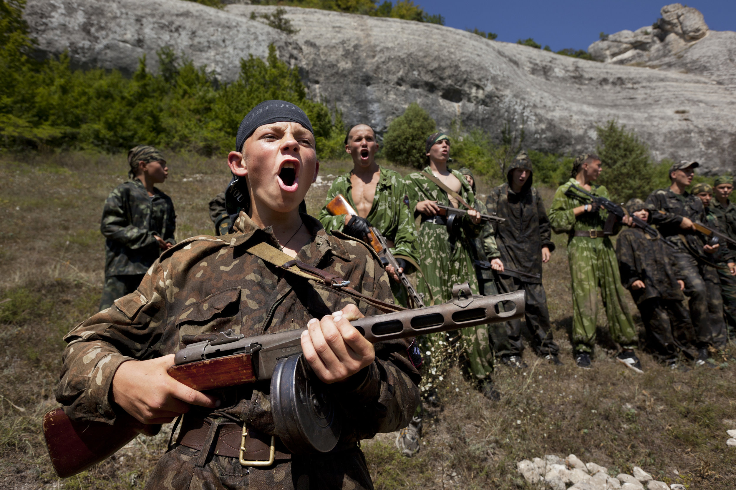  Holding a machine gun, a young boy calls out before a drill.  Eski-Kermen Region, Crimea  