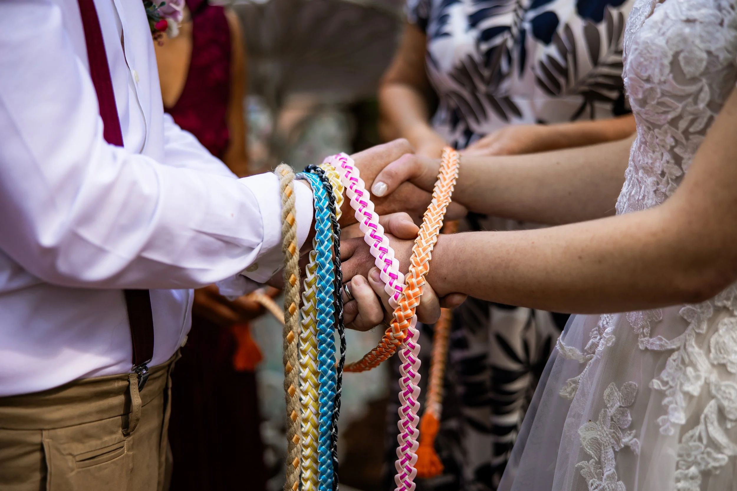 A wedding handfasting ceremony with the bride and groom holding hands at Cheshire Woodland Weddings