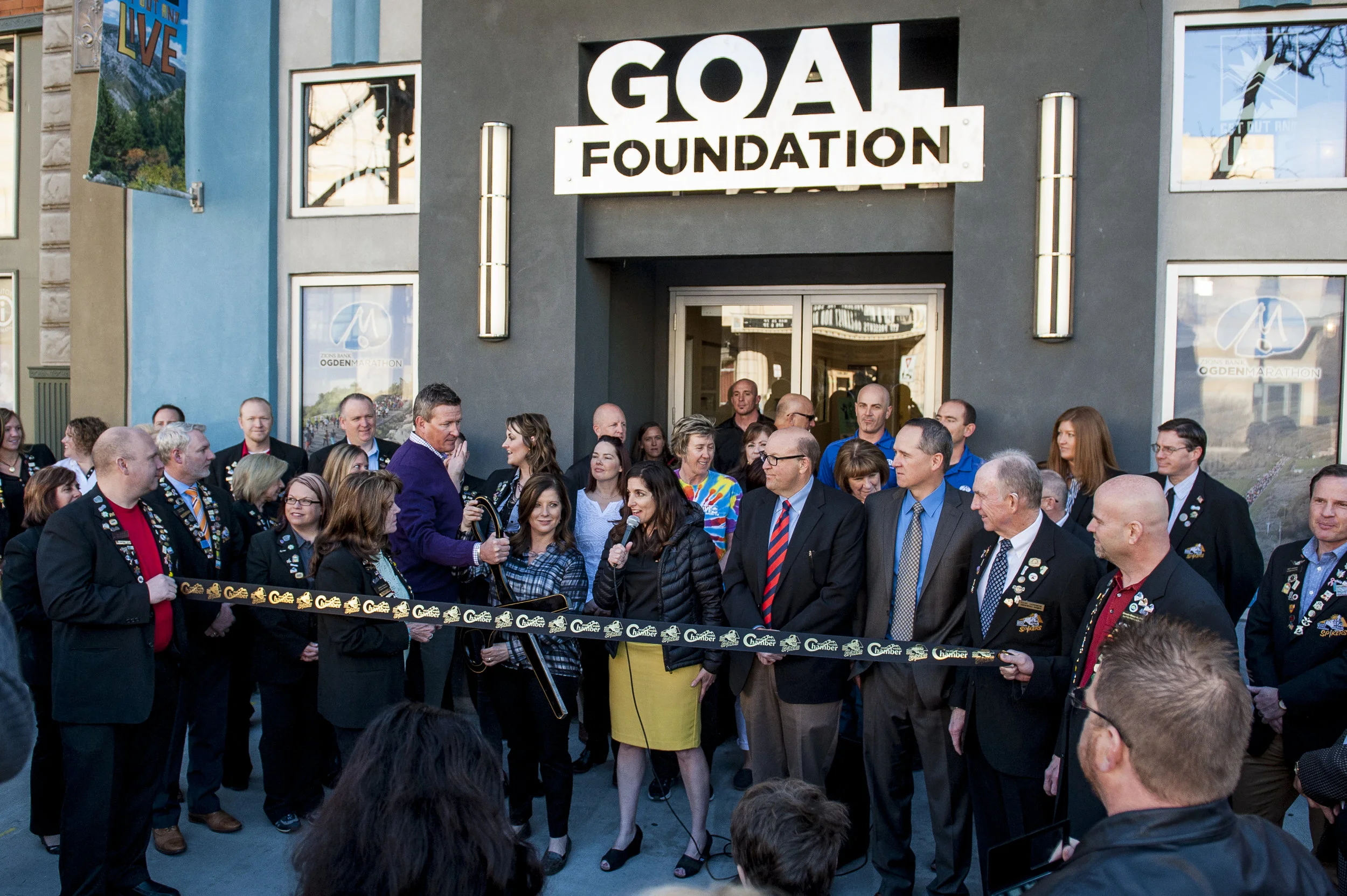 Mikelle Barberi Weil (center), GOAL Board President, speaks to the crowd who has gathered to watch the ribbon cutting and see the new GOAL Foundation offices located at 2440 Washington Boulevard in Ogden on March 26, 2015.