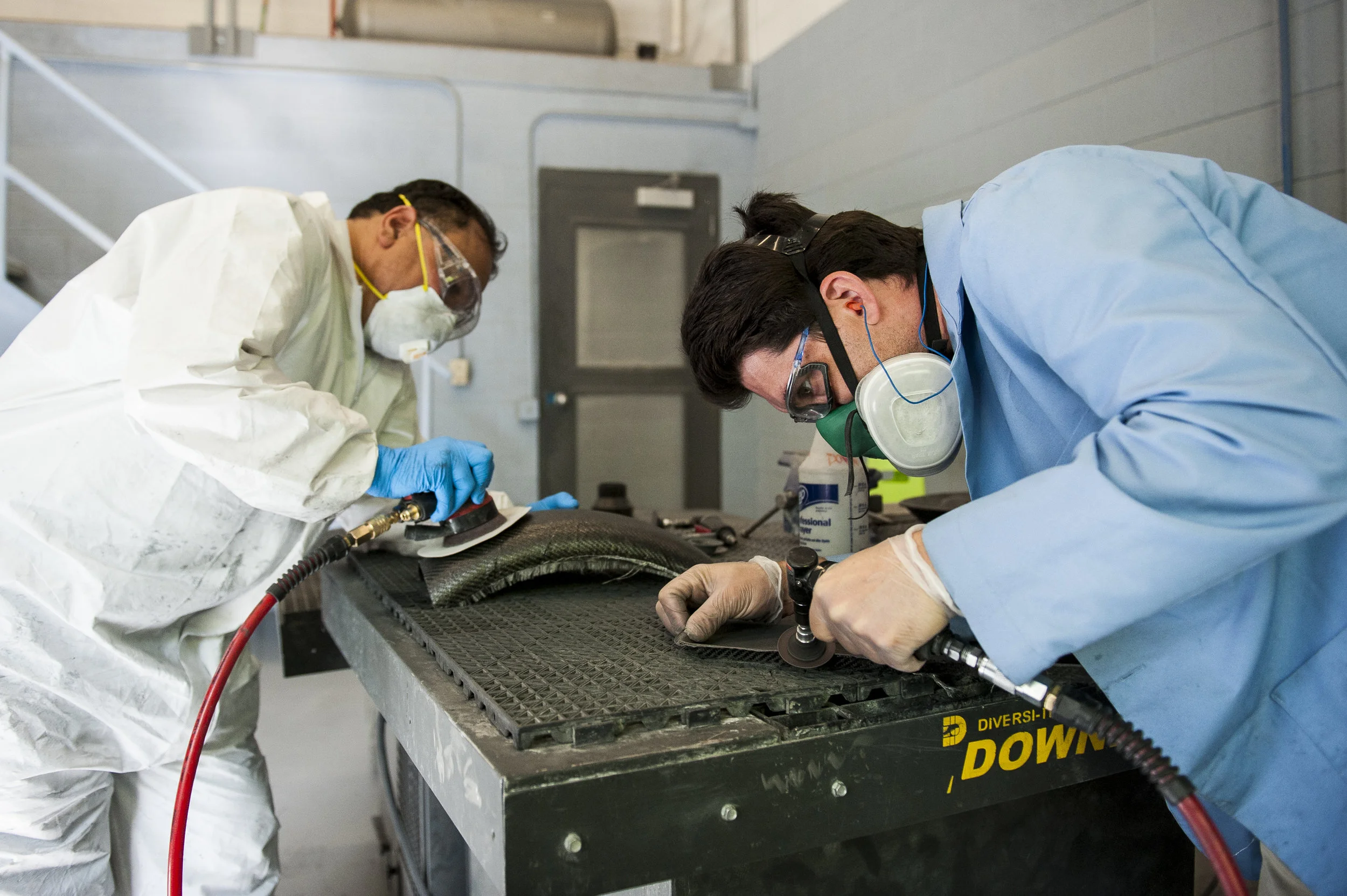 Hector Rivera (left) and Nate Caulford (right), students in the composites department at the Ogden Weber Applied Technology Center, work on their sanding techniques in Ogden on May 4, 2015.