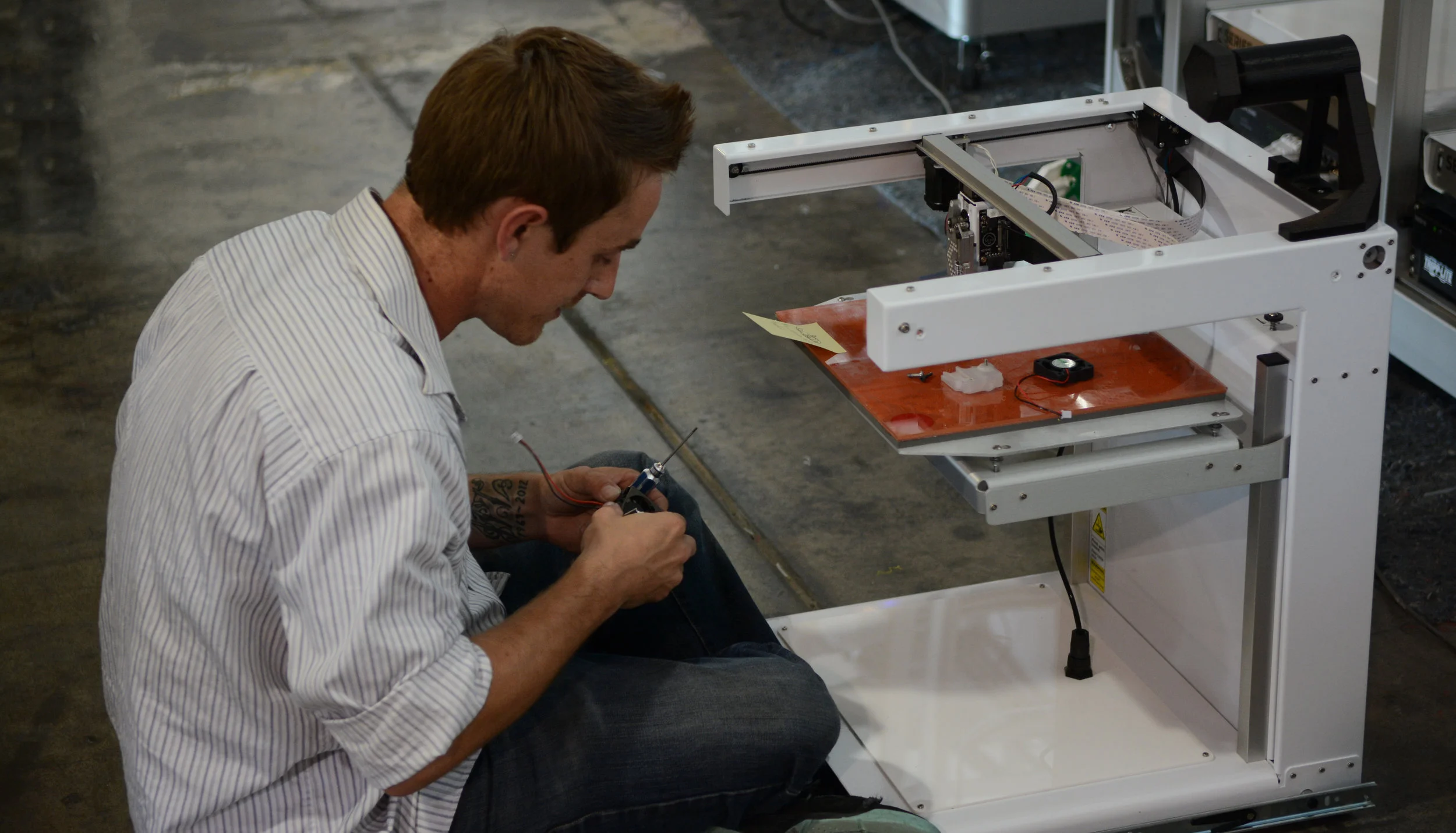 Technician-on-ground-with-3D-printer-repair-machine.jpg