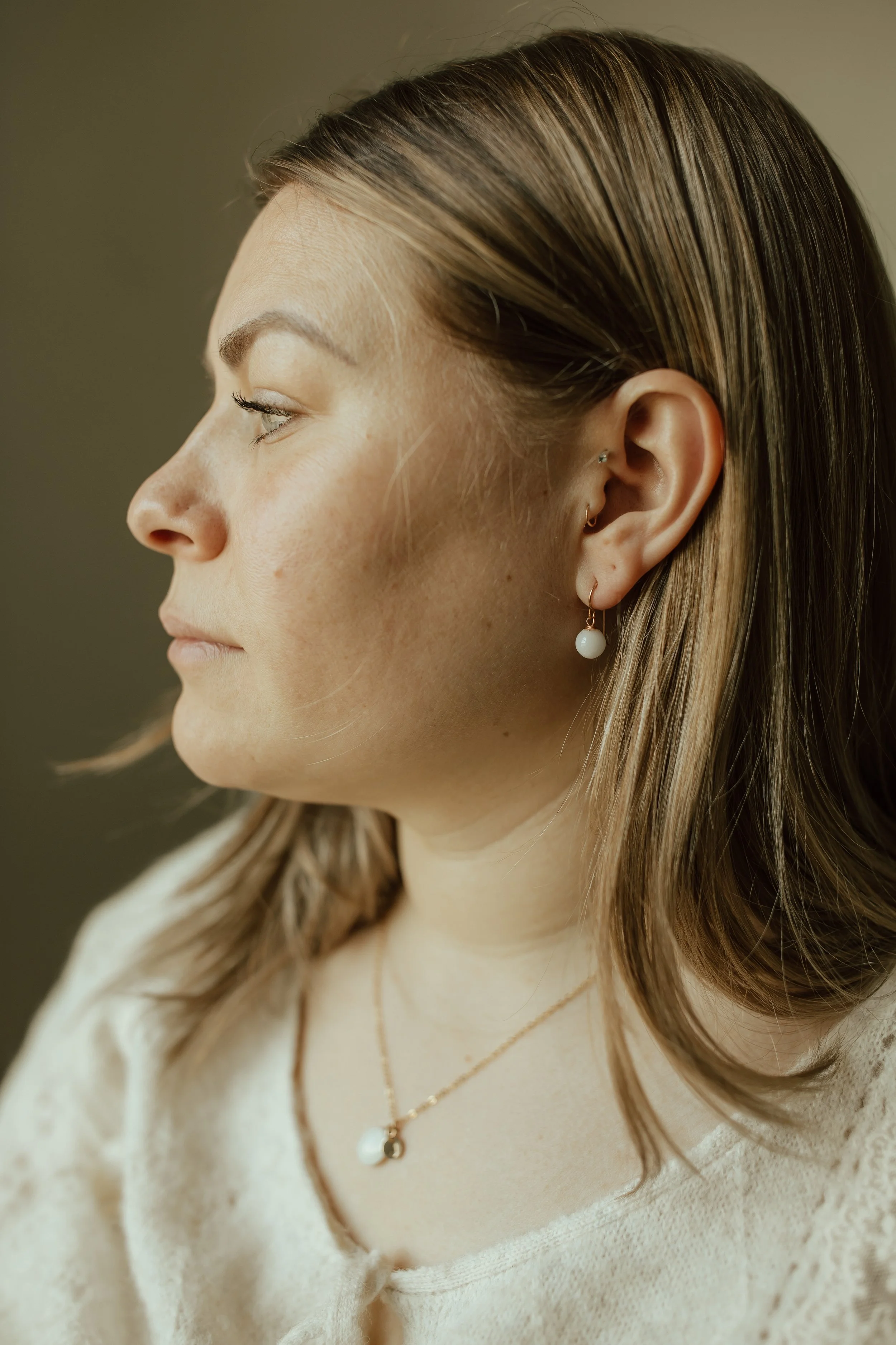 Woman wearing yellow gold Pearl Drop Earrings with hook backs