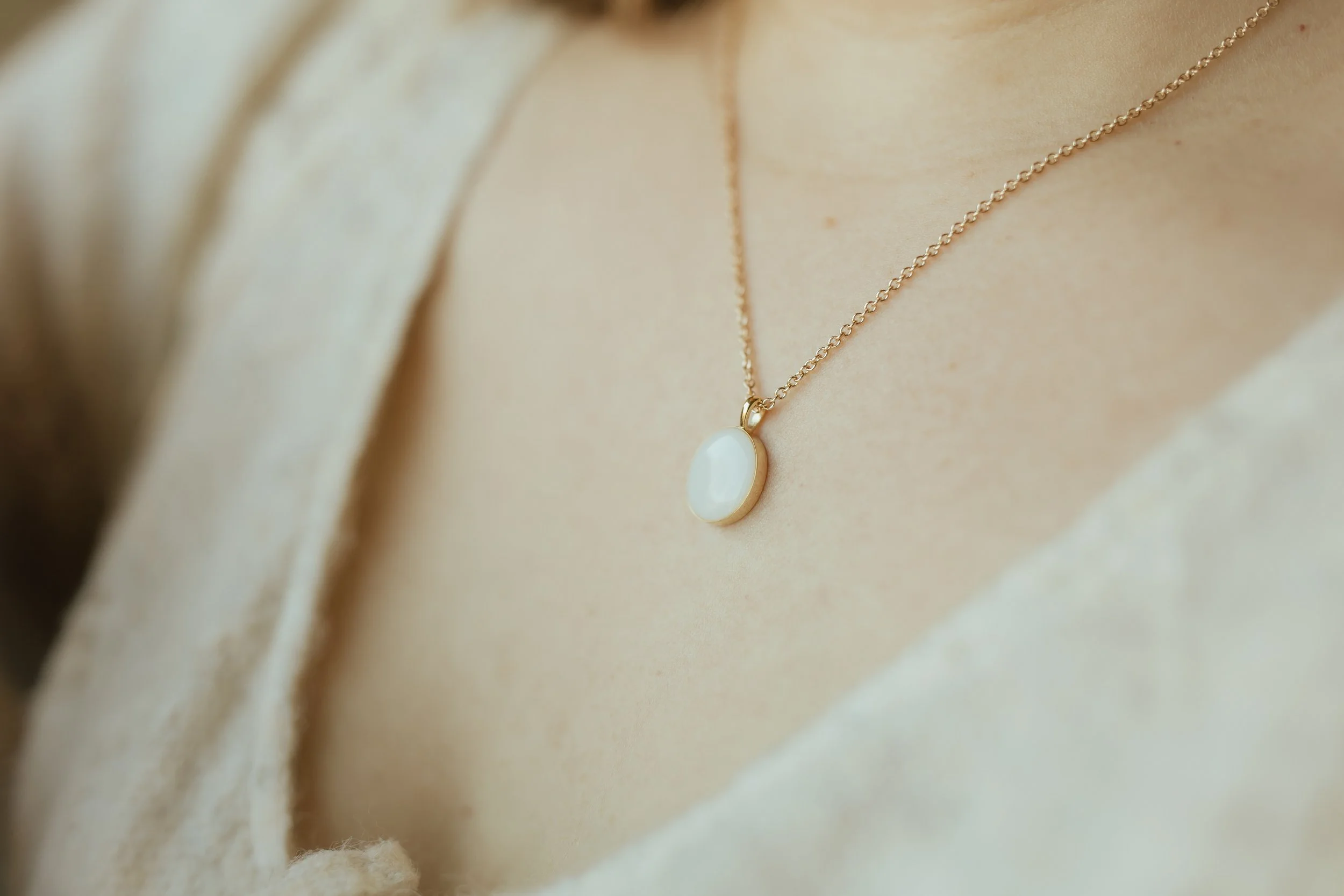 Woman wearing Solid Yellow Gold Heirloom Oval necklace made with breastmilk