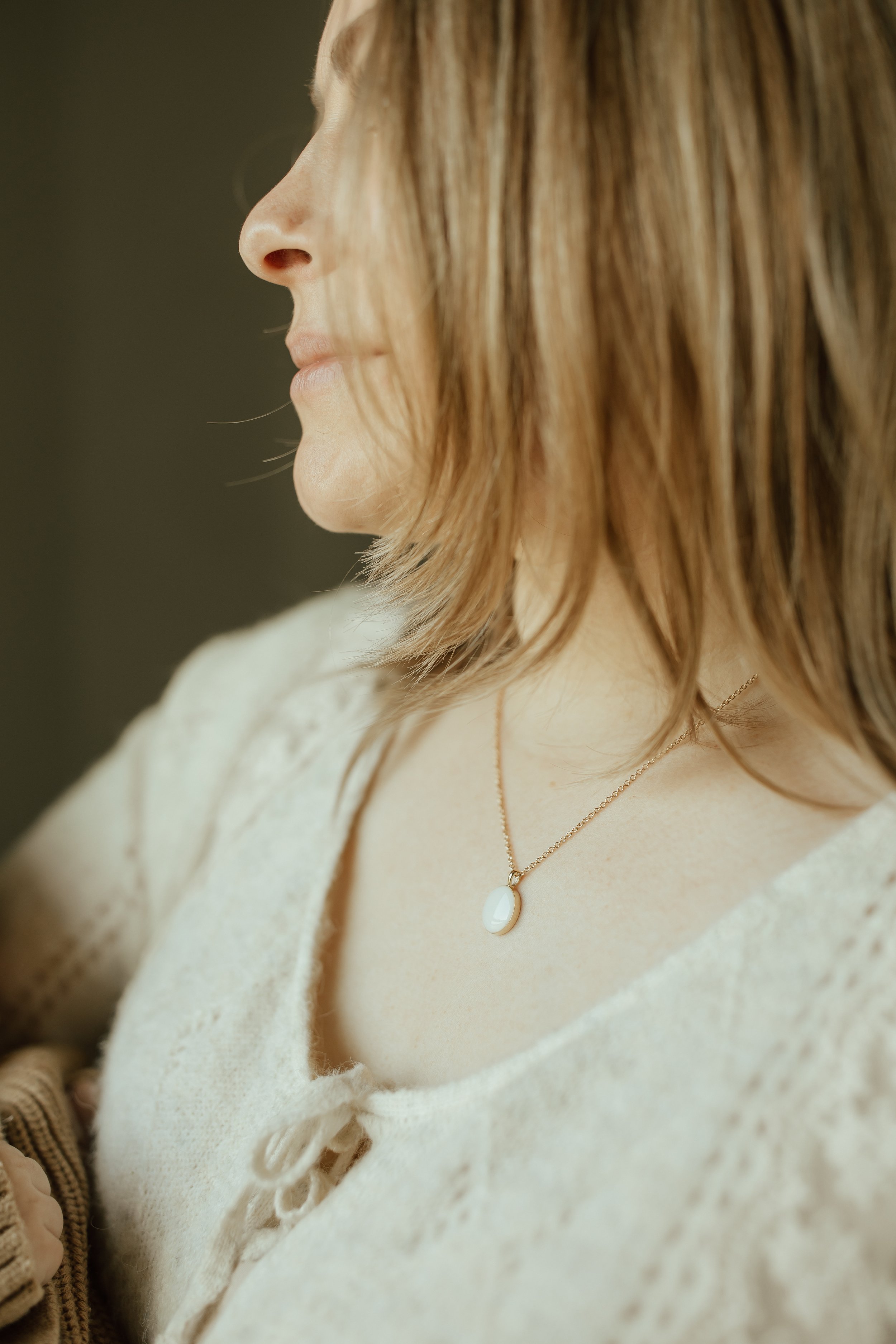 Woman wearing Solid Yellow Gold Heirloom Oval necklace made with breastmilk