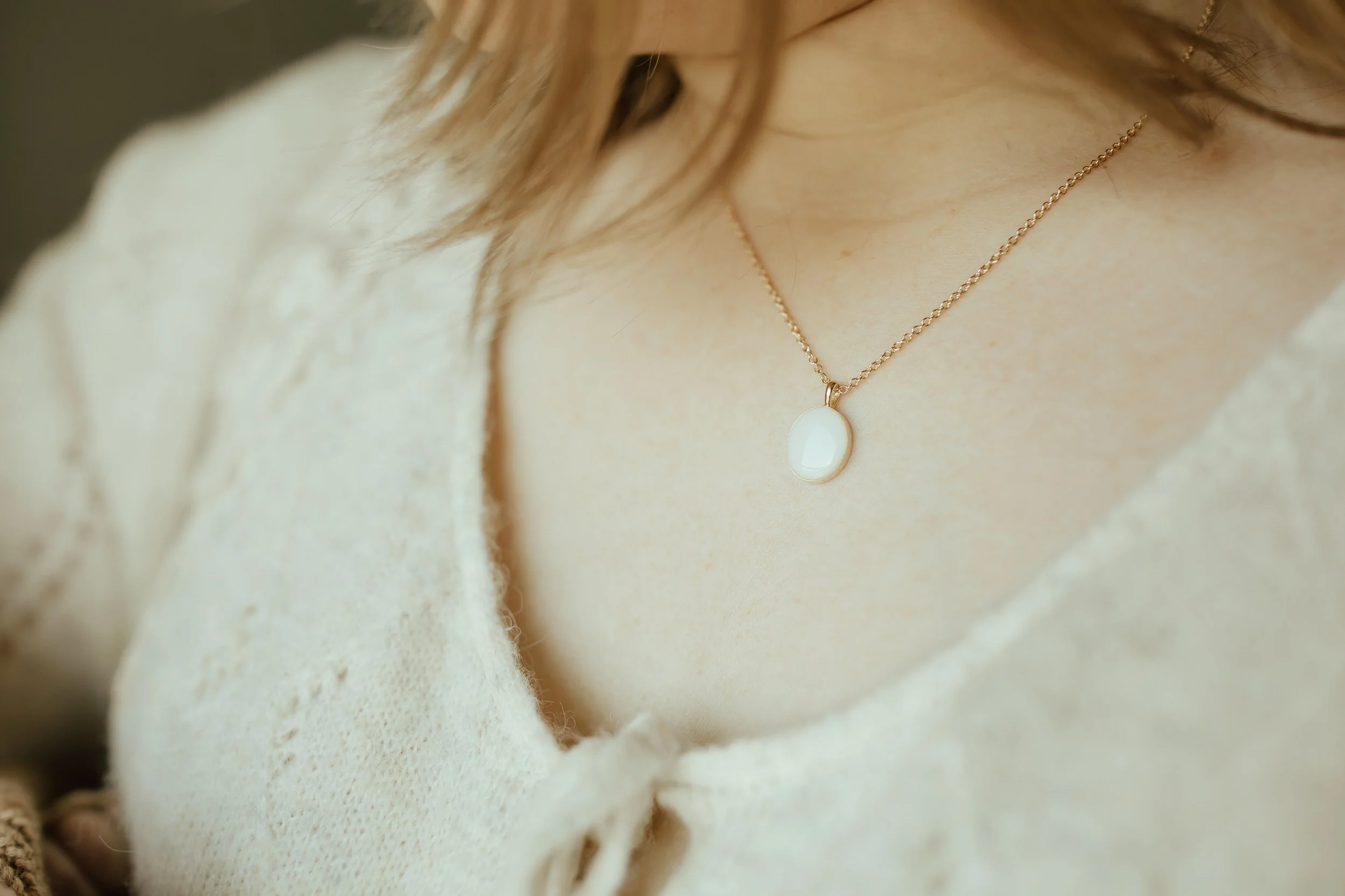 Woman wearing Solid Yellow Gold Heirloom Oval necklace made with breastmilk