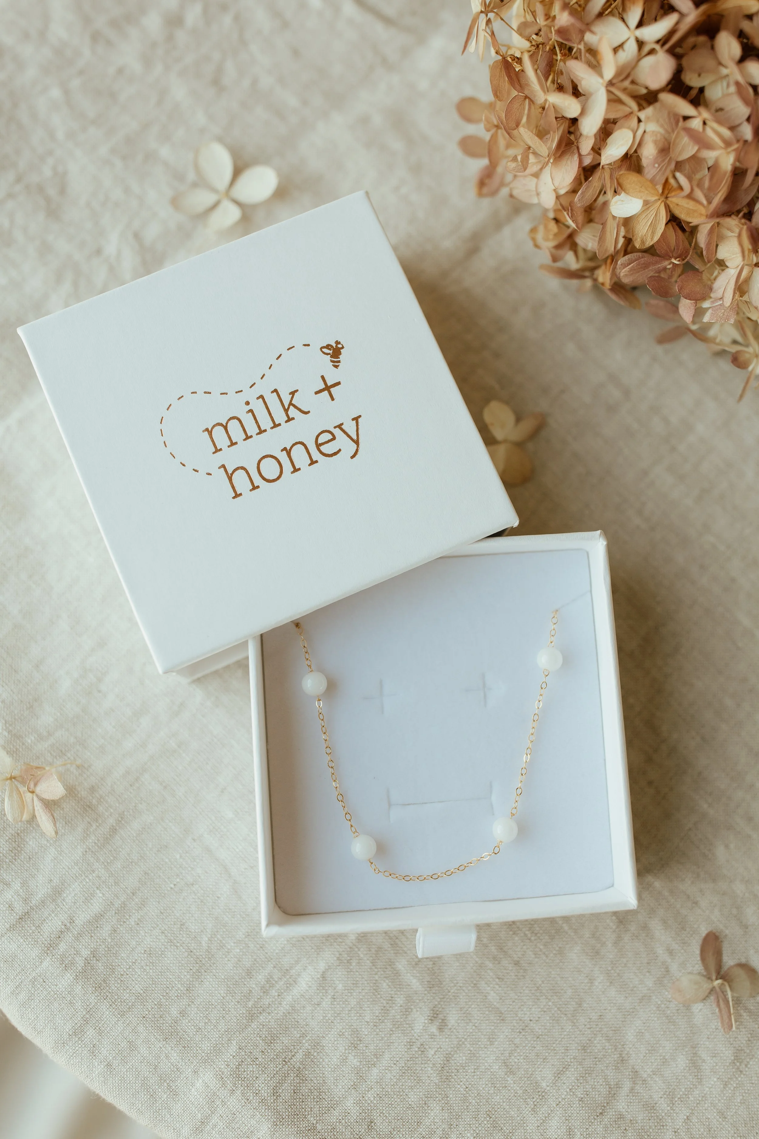 Yellow Gold Petite Pearl choker with 6 pearls spaced out in Milk + Honey Box
