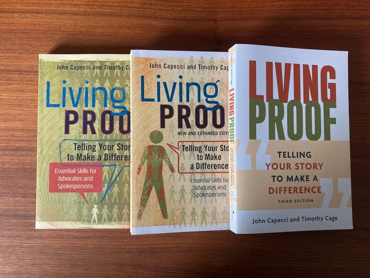 Three editions of Living Proof Telling Your Story to Make a Difference by John Capecci and Timothy Cage, including the new third edition.webp