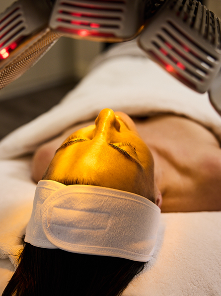 Healite II LED machine over clients face, using infrared LED to reduce inflammation.