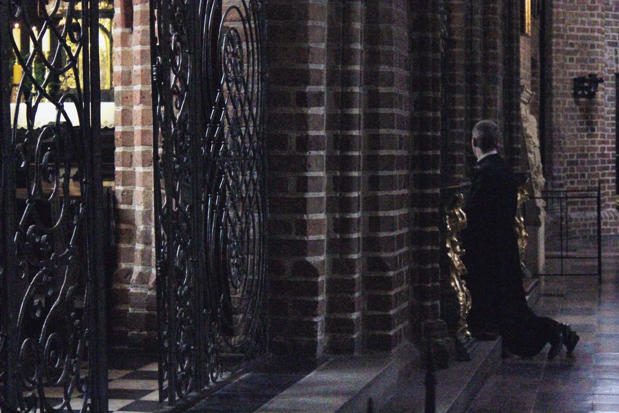 Poland Poznan Church Priest Kneeling Praying.jpg