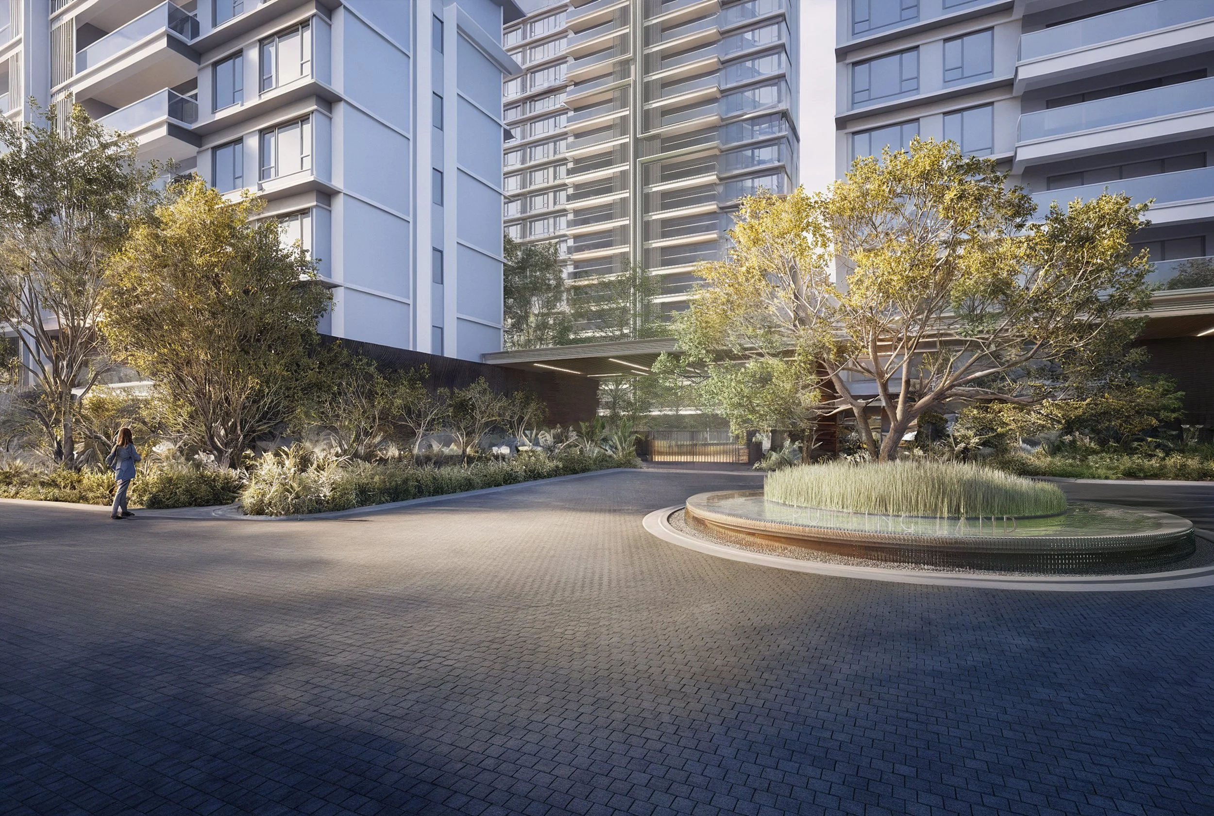 Modern residential building with landscaped entrance, trees, low shrubs, and a woman walking along the driveway.