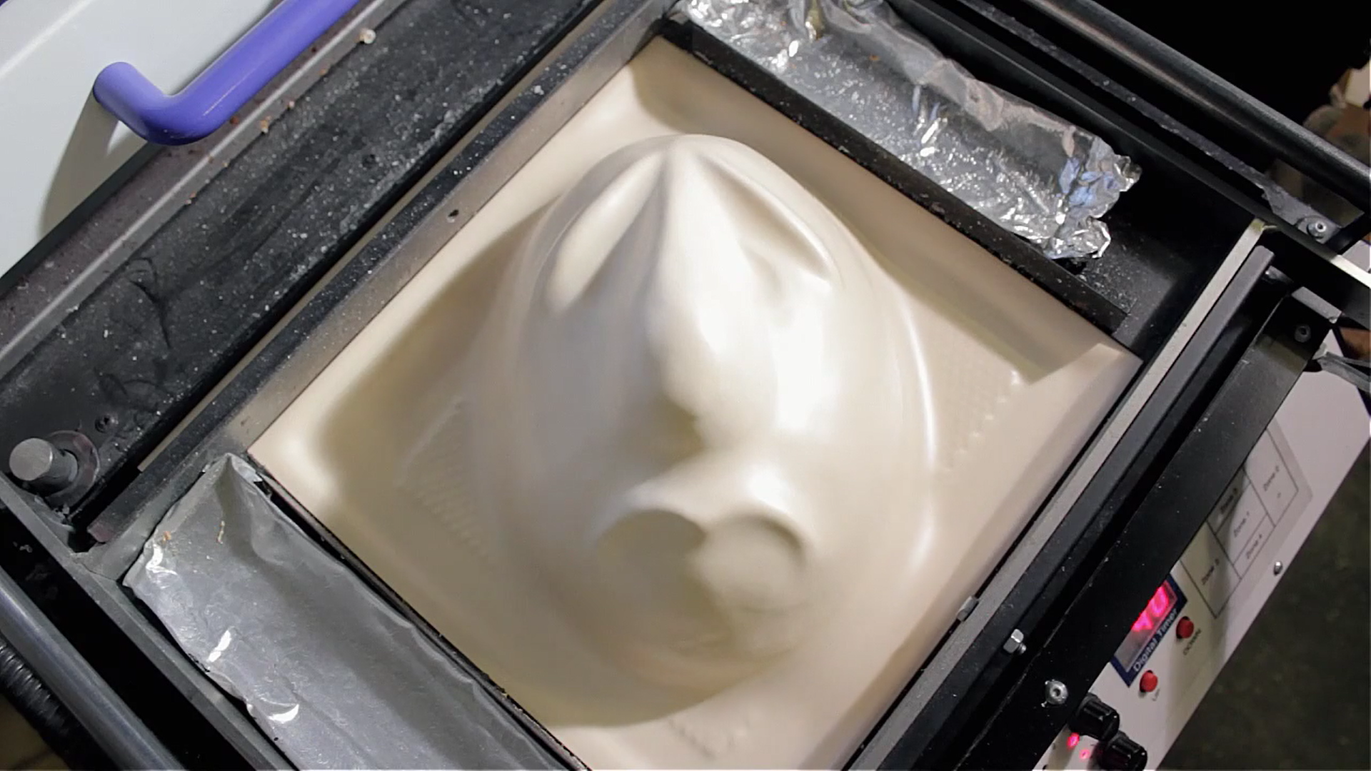 4) After about 20-30 seconds we see that the plastic has taken to the contours of the mould. We lift the plastic off the mould and let it cool for a moment.