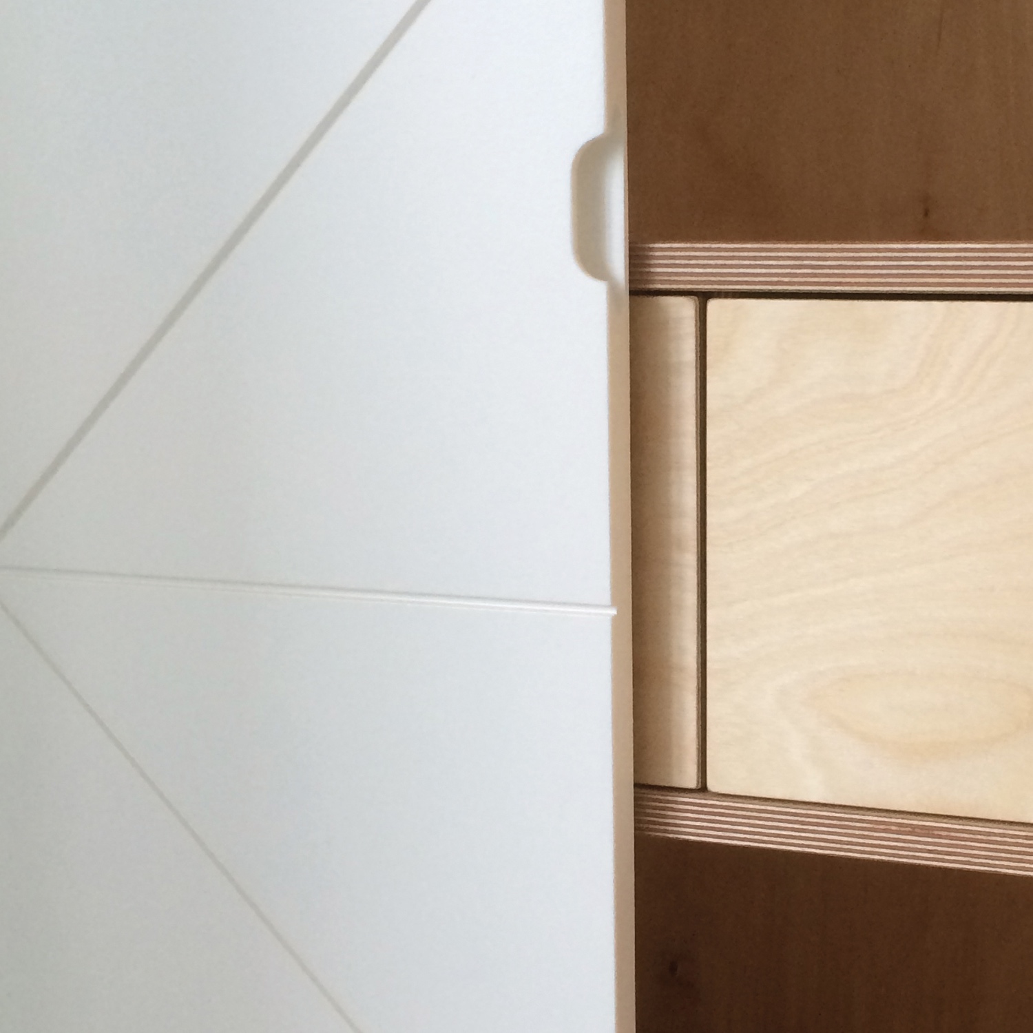 Close up detail image from  a hand crafted wardrobe, it have birch plywood interior and white painted doors. 