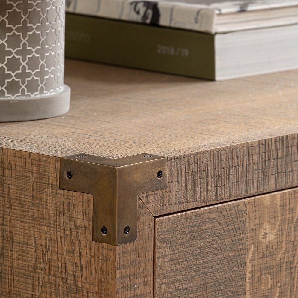 A close up image of a Rustic styled Sideboard made in textured band sawn Oak, with an aged brass corner plate. 