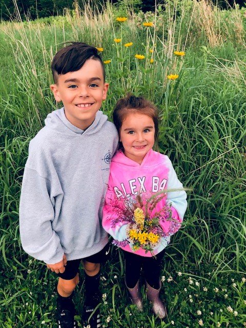 smiling kids at Cornwall with flowers.jpg