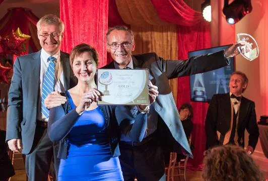 Bernadette Clement and Dr. Jens Van Roey accepting the Johnson and Johnson CSR Trust Award for the Caring Together project in 2015.