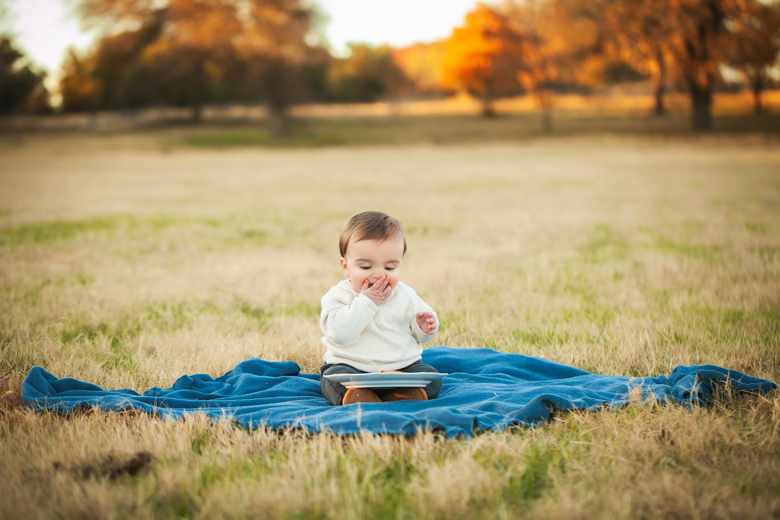 cake-smash-photographer-first-birthday-boy-eating-cake-colleyville-outdoor-portrait-photographer