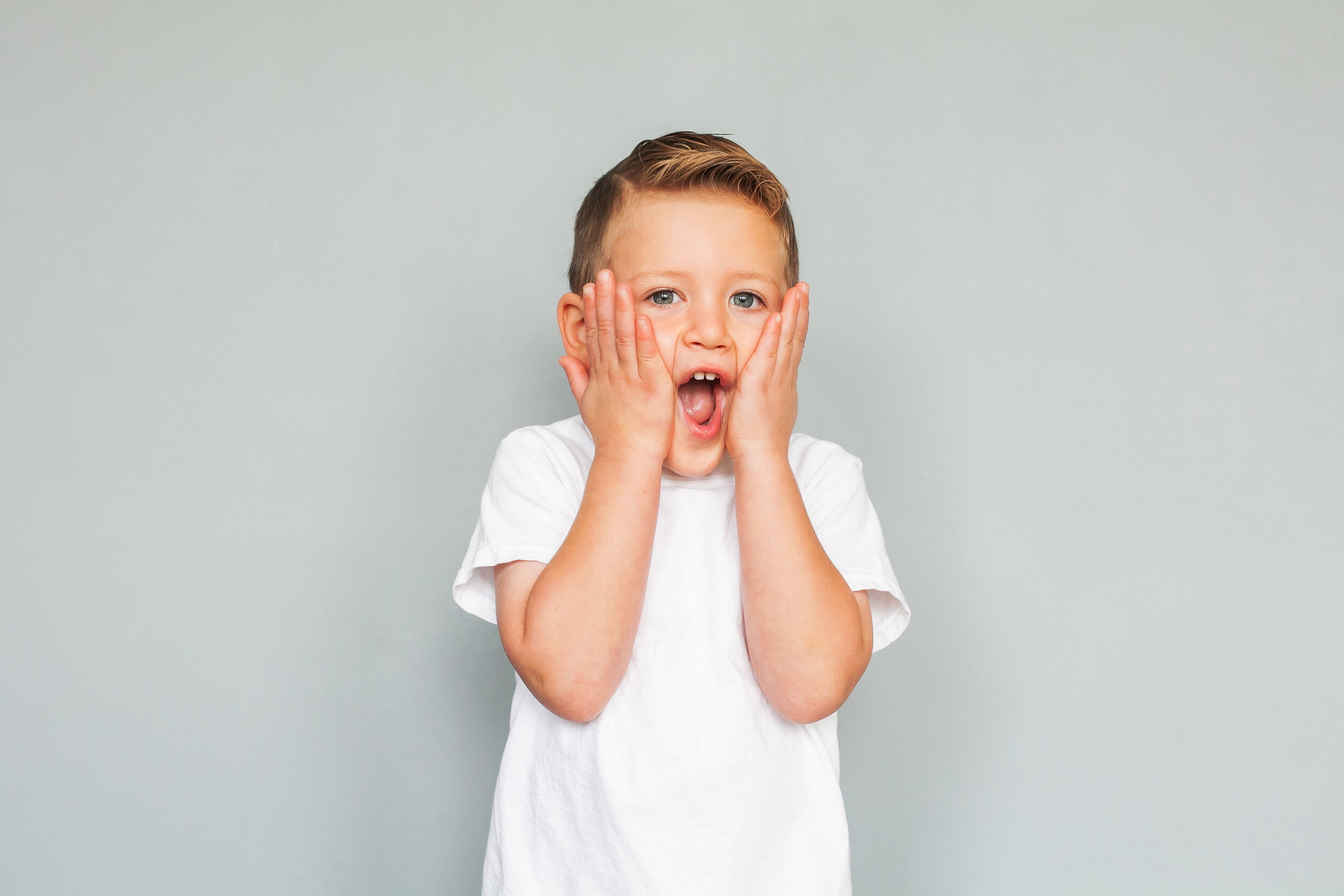 surprised-expression-gray-background-white-t-shirt-boy-studio-portrait-photographer-fort-worth