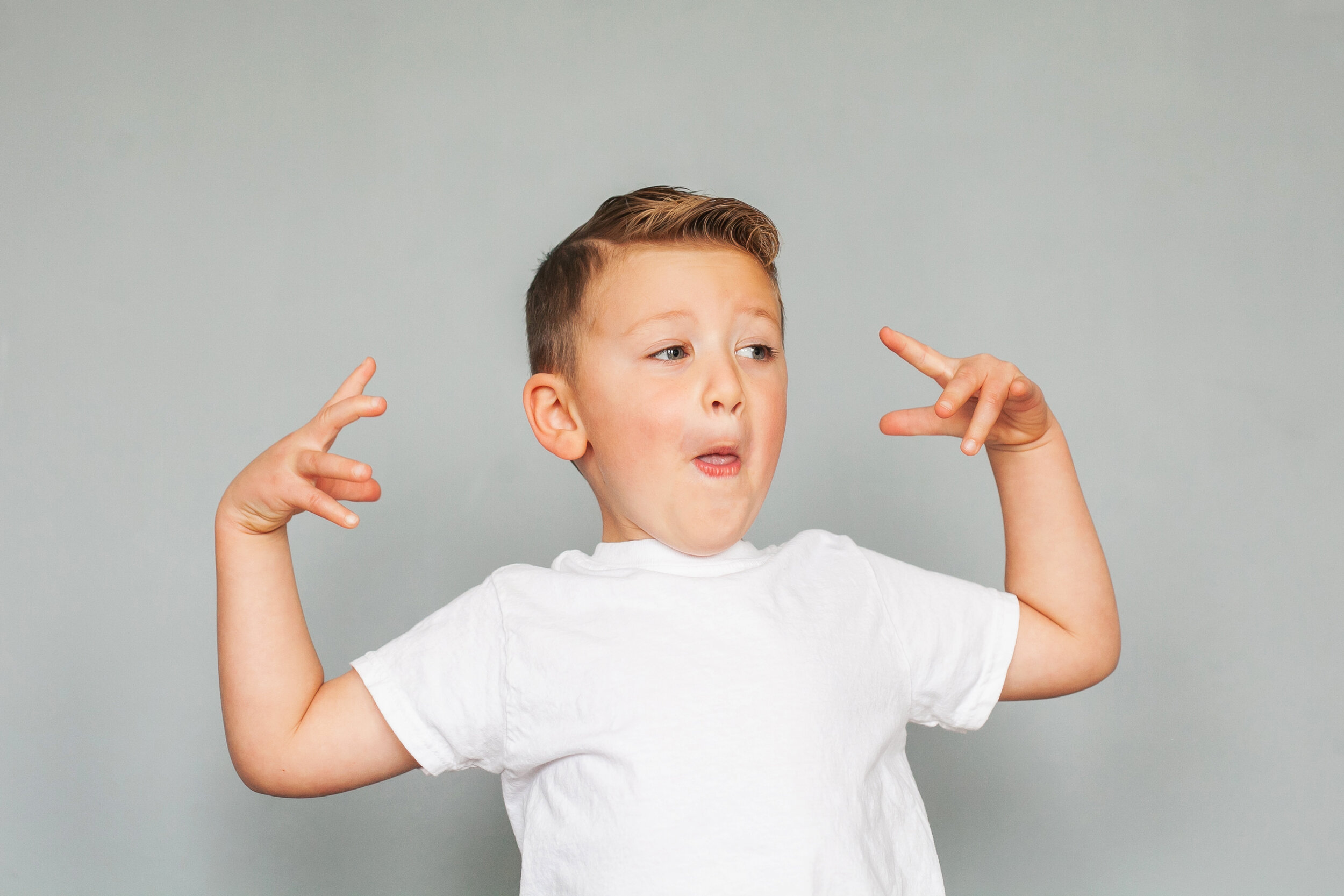 boy-faces-expressions-in-studio-gray-background-studio-children's-headshot-portrait-photographer-fort-worth