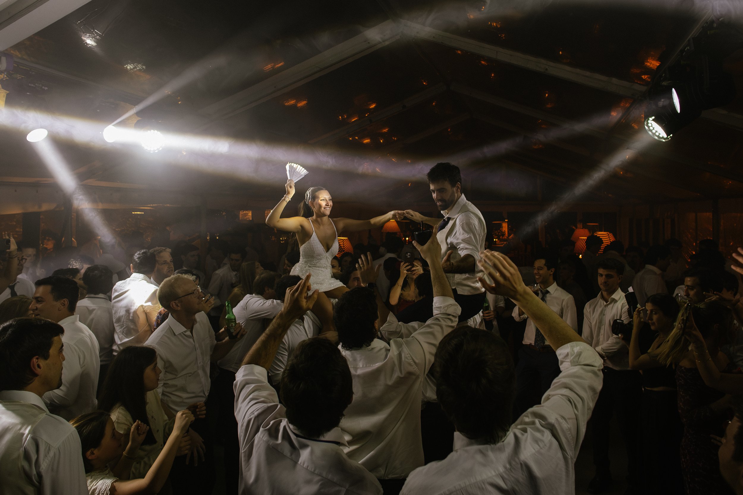 Personas bailando en una fiesta con luces y gente disfrutando.