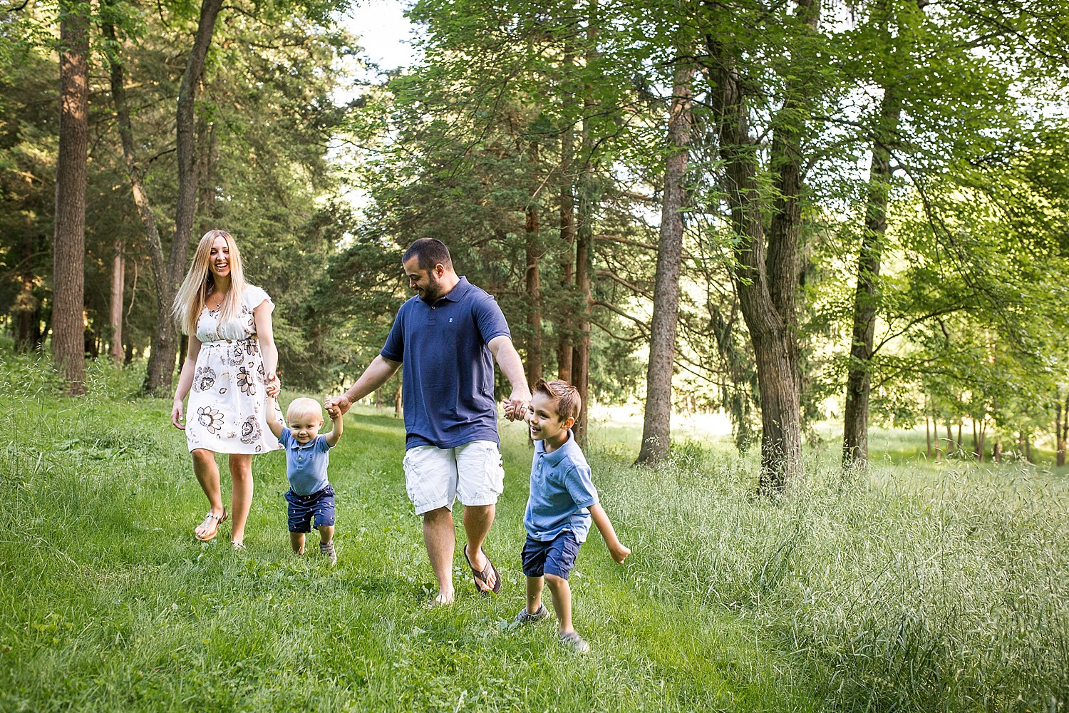  Photo of a family of four walking down a path in the woods. 