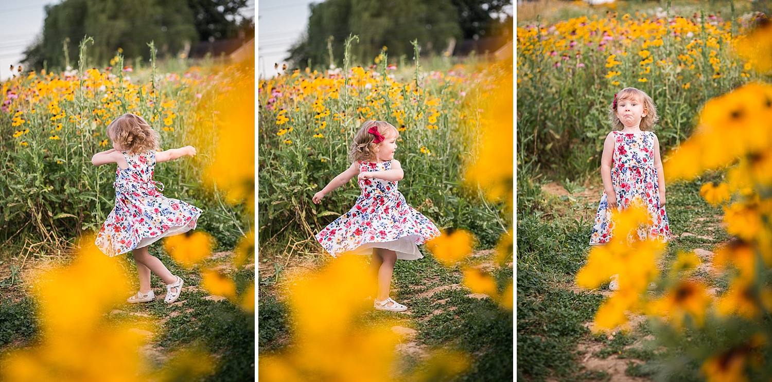  A little girl wearing a flowered dress twirls in a field of yellow wildflowers. 
