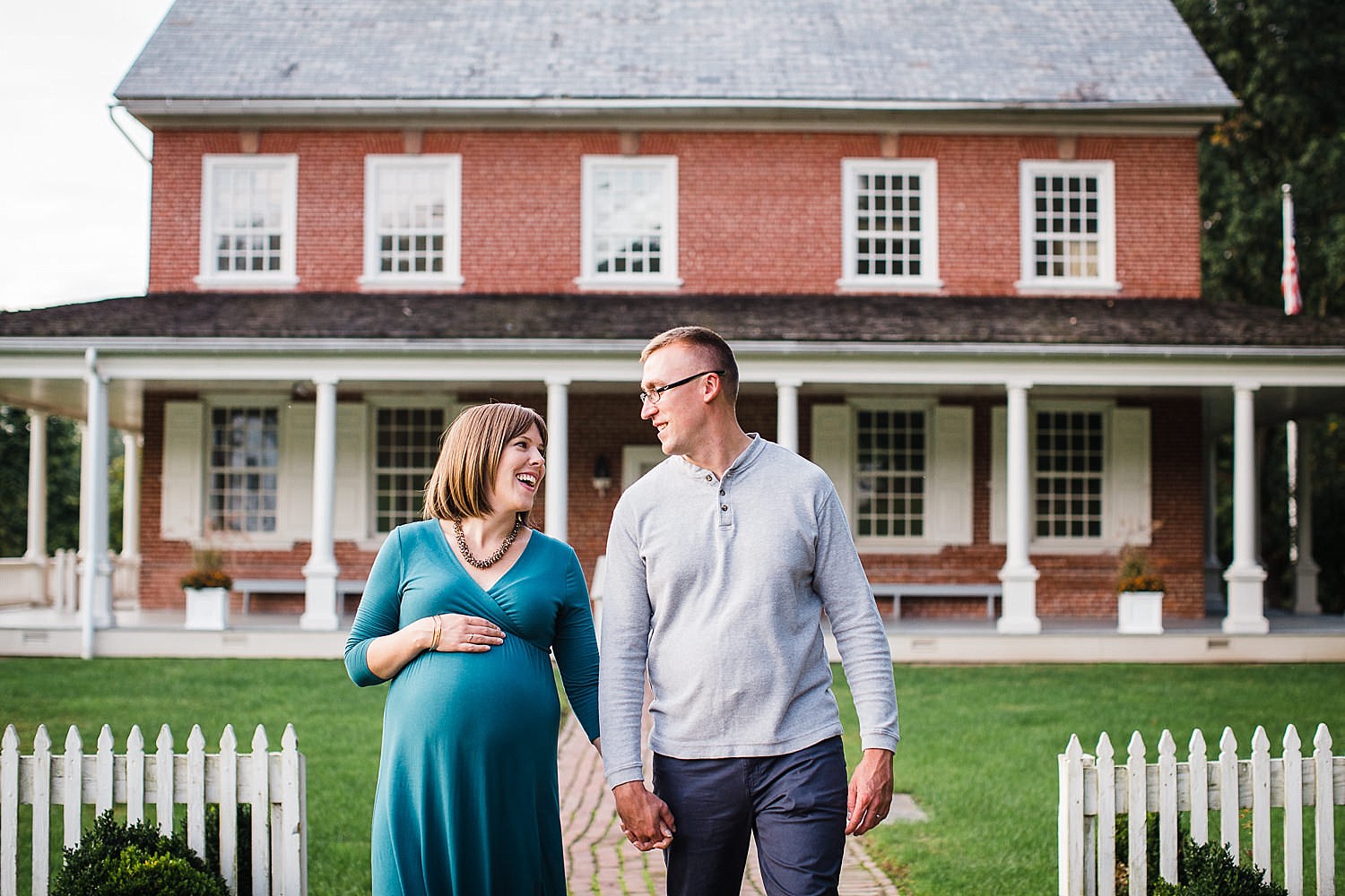  Photo of a pregnant woman and her husband walking down a path hand in hand. 