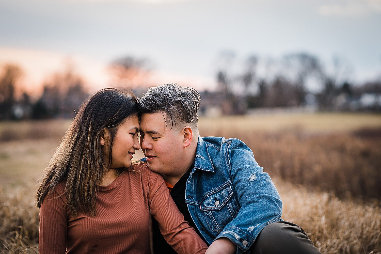  Asian couple sitting on a blanket at sunset 