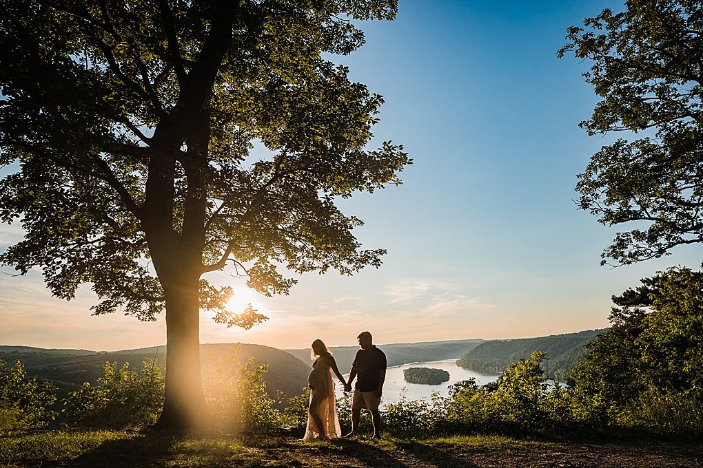 couple silhouette on a river overlook at sunset