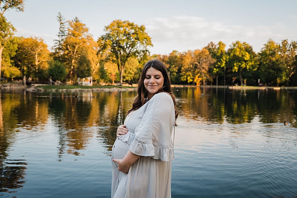 Pregnant mom stands by the water