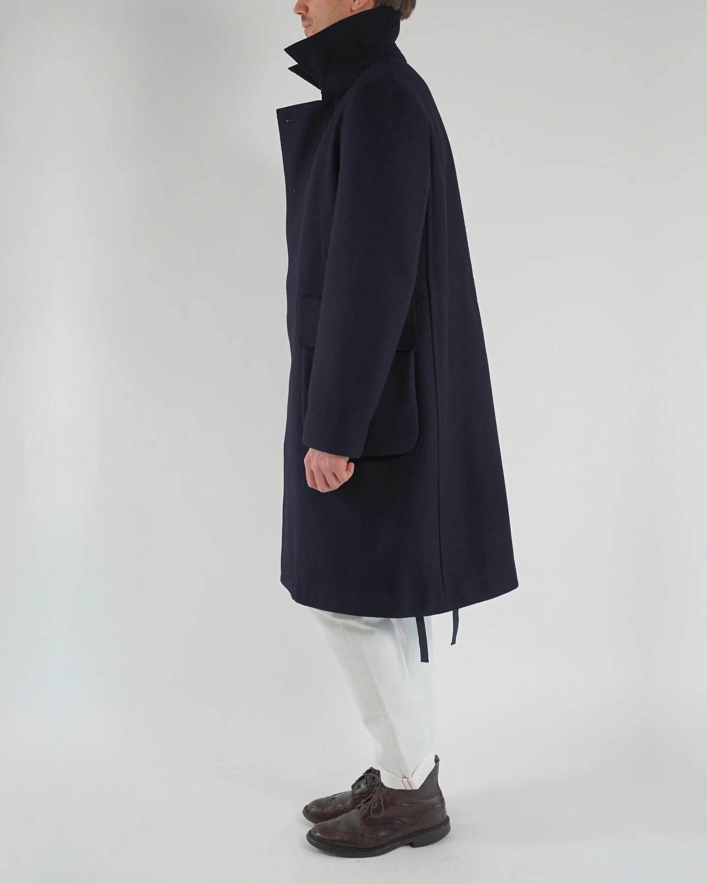 Designed with the emblematic Austrian #Loden.
A reinterpretation of the classic loden #coat, with details from the world of #tailoring and references to military clothing. The oversize loden coat is now available in navy, black and dark grey. In stor