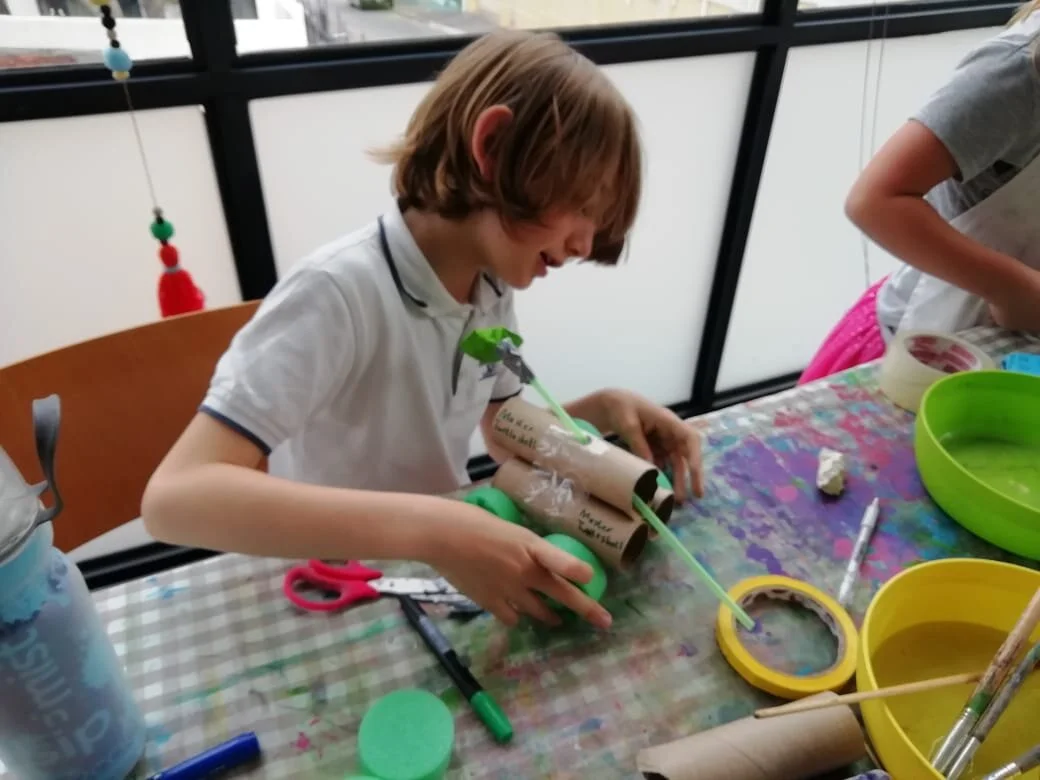 This boy used toilet rolls for his body. He had to lengthen his sosati sticks so that the wheels does not get stuck. It still would not move that well and then he came up with the idea to add another balloon. Then his car raced over the floor!