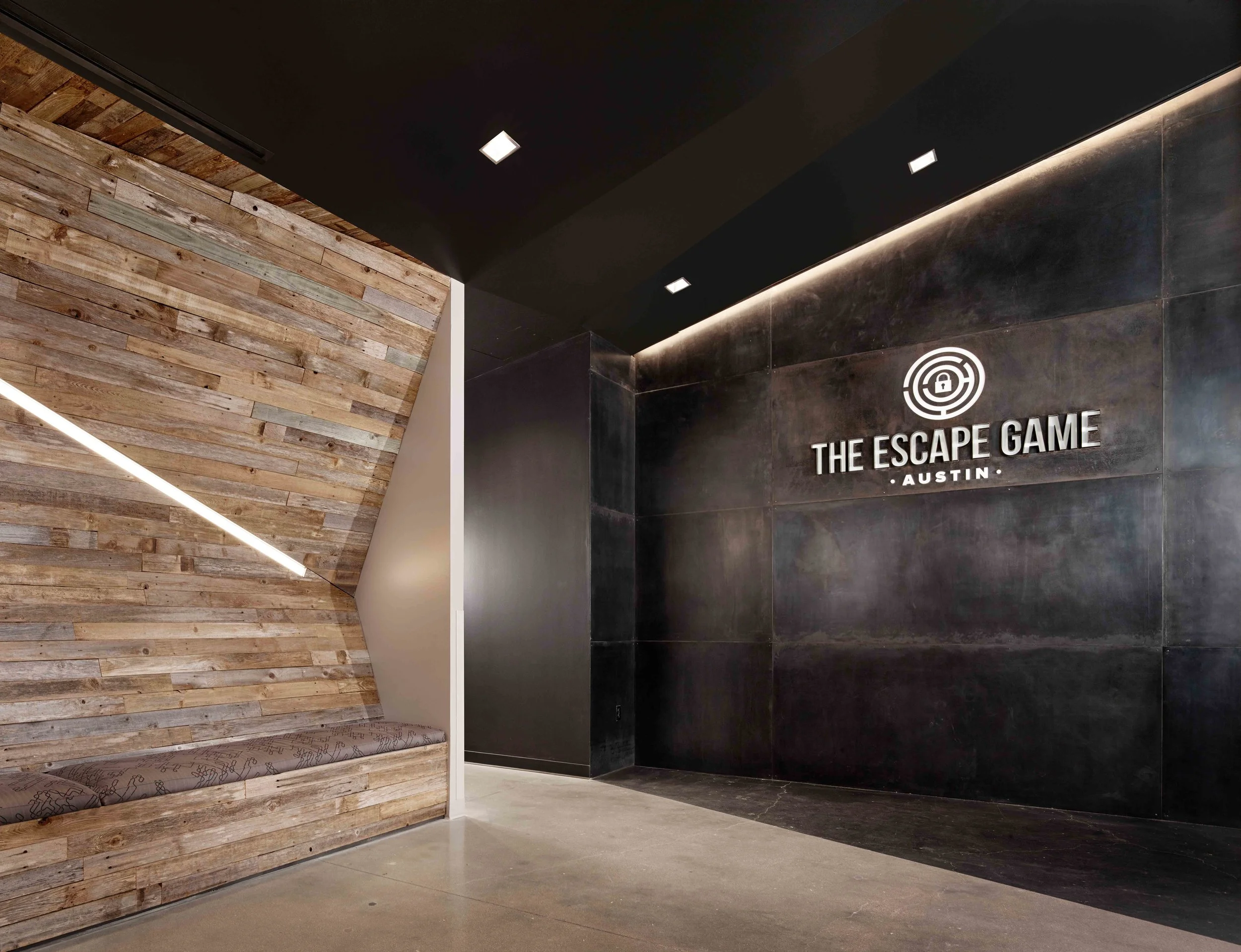 THE ESCAPE GAME AUSTIN | interiors, graphics, ffe The Escape Game Austin (TEG) is a new entertainment experience where participants must find clues and solve puzzles in order to “escape” from a series of “locked” rooms. The entrance to TEG celebrates both the business identity and gaming concept through seemingly distorted architecture. Entering the space, angular forms challenge the viewer to ponder multiple perspectives: floors, walls and ceilings invade one another in striking, confusing forms. The bizarre nature of the room stimulates the brain’s innate drive to rationalize that which it perceives. Within a gaming context, this can mean seeking reasonable solutions to fun but confusing experiences; thus, the entrance itself becomes an entertaining puzzle which one must solve. The space also serves as a psychological transition between the outside world and TEG, preparing participants for the games that follow. Client: The Escape Game Location: Austin, Texas Size: 4,000 square feet