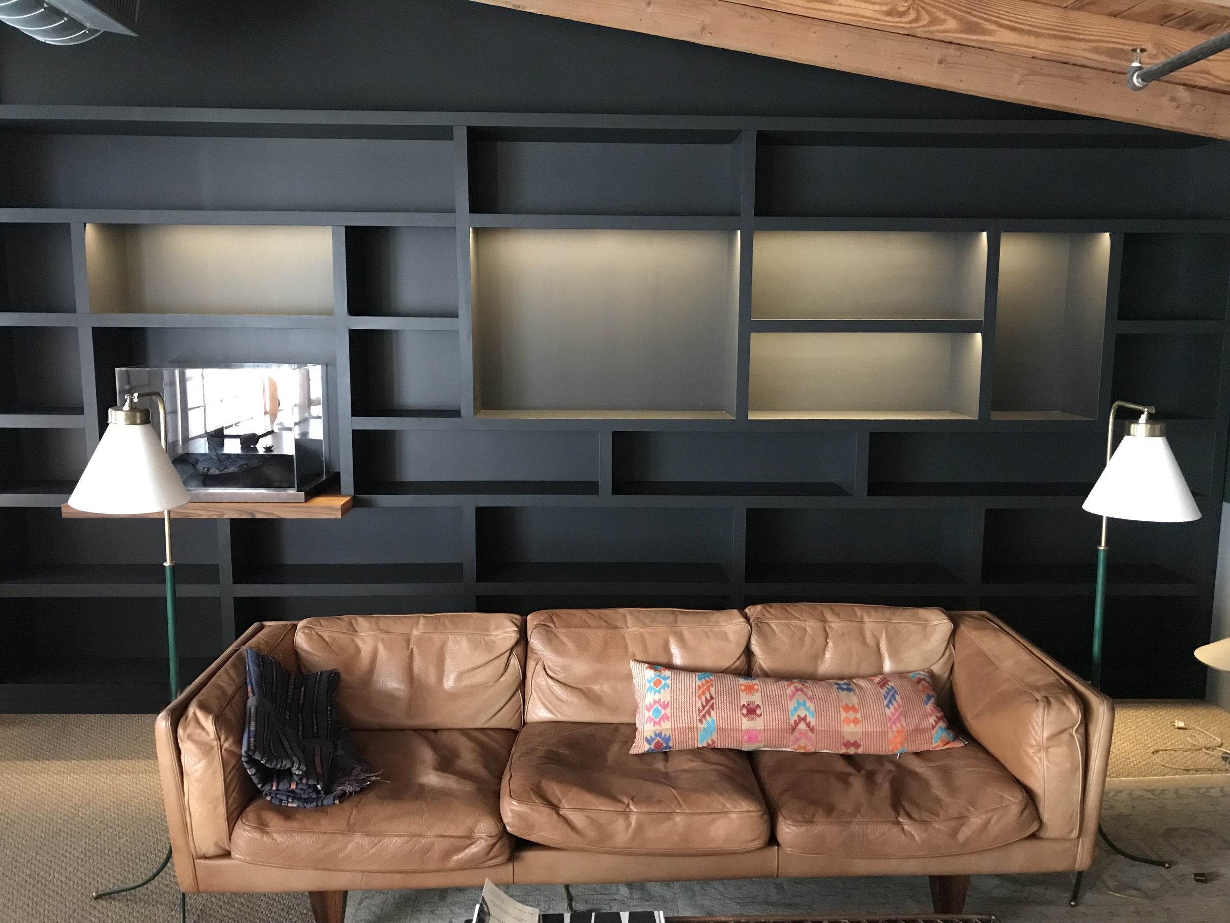 Birch and teak plywood, remote-controlled dimmable LED lighting system, black paint. Writer/Director Alejandro González Iñárritu needed a bookcase in his office to display, among other items, the mask Michael Keaton wore in Birdman. The whole unit assembled is 16’ x 7-1/2”: too big to fit up the stairs (with a 180 degree turn halfway up) to his office, so I designed 8 separate modules that nest together.