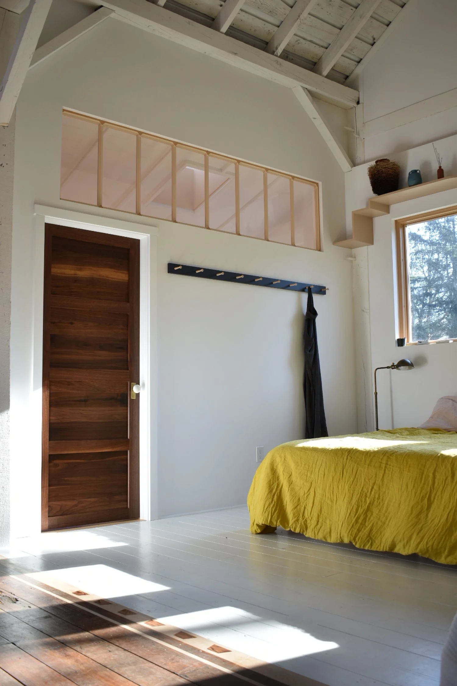  A bedroom alcove. A walnut door leads to the bathroom. Transom windows simultaneously divide and reveal. 