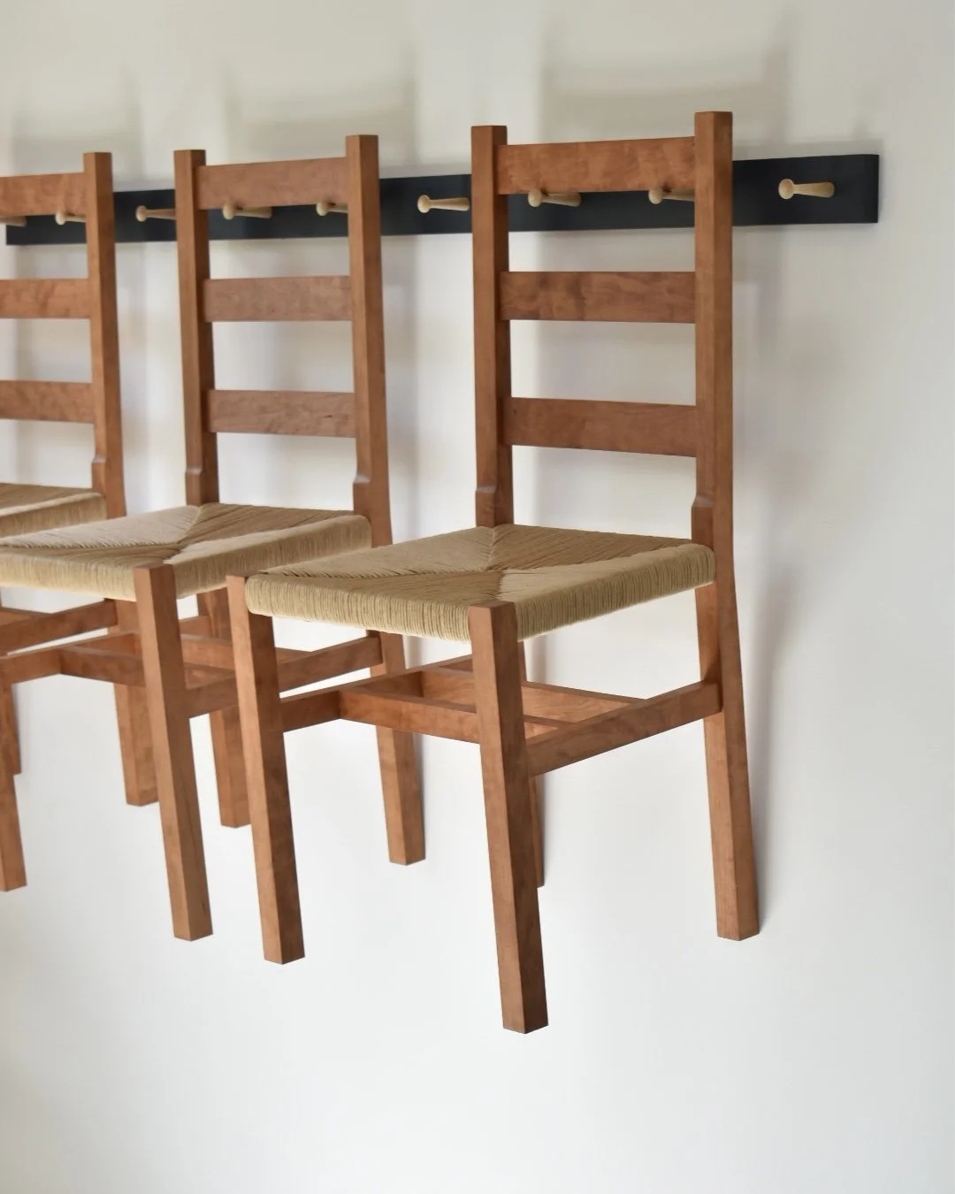  A set of ladder back dining chairs in cherry and fiber rush.  