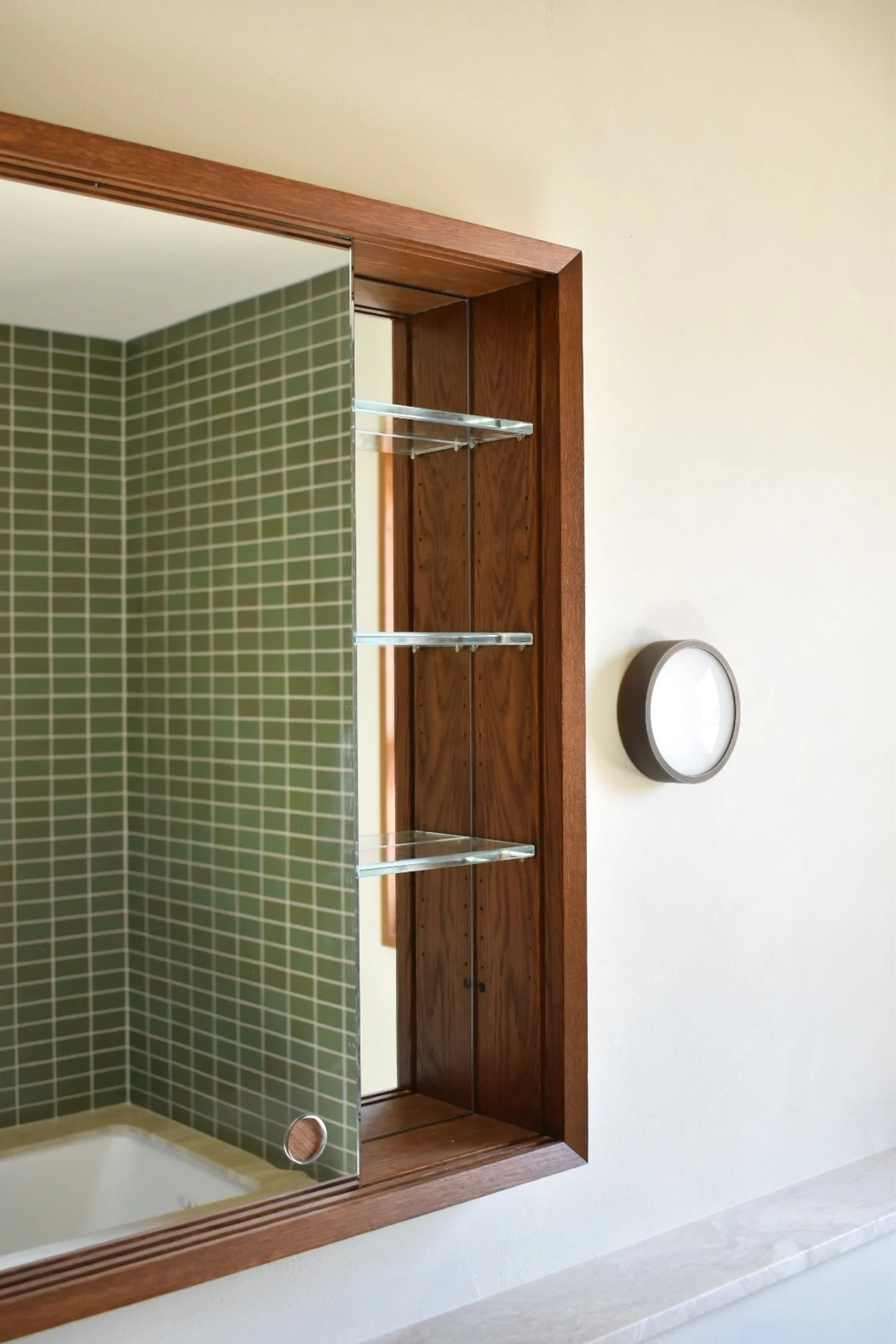  Bypass doors reveal low-iron glass shelving and a mirrored case back. 