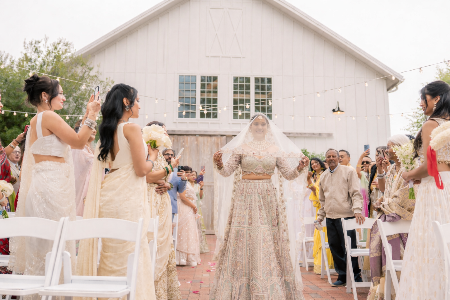 South Asian bride walking down the aisle during an outdoor wedding ceremony at The Barn of Chapel Hill