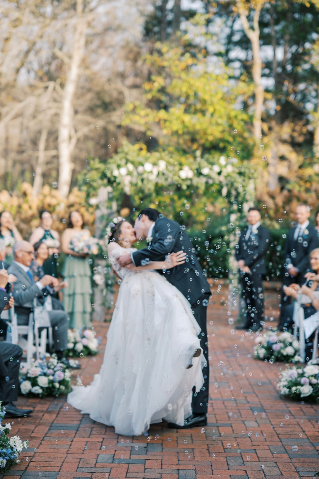 Bride and groom celebrating their first kiss during a garden ceremony at The Barn of Chapel Hill
