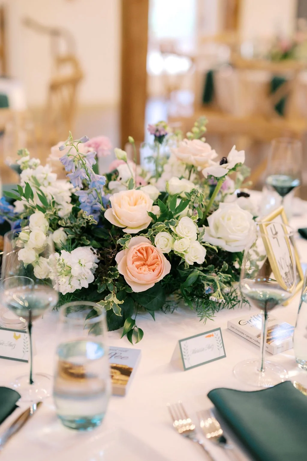 Wedding reception table centerpiece with pastel garden flowers and elegant place settings at The Barn of Chapel Hill in North Carolina