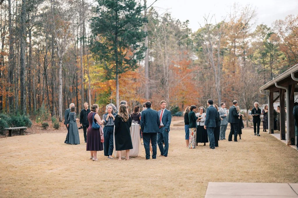 Wedding guests mingling during outdoor cocktail hour on the lawn at The Barn of Chapel Hill in North Carolina