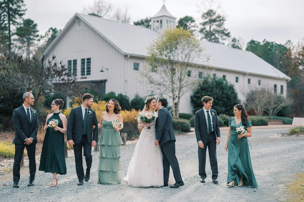 Bride and groom with their wedding party walking outside The Barn of Chapel Hill in North Carolina