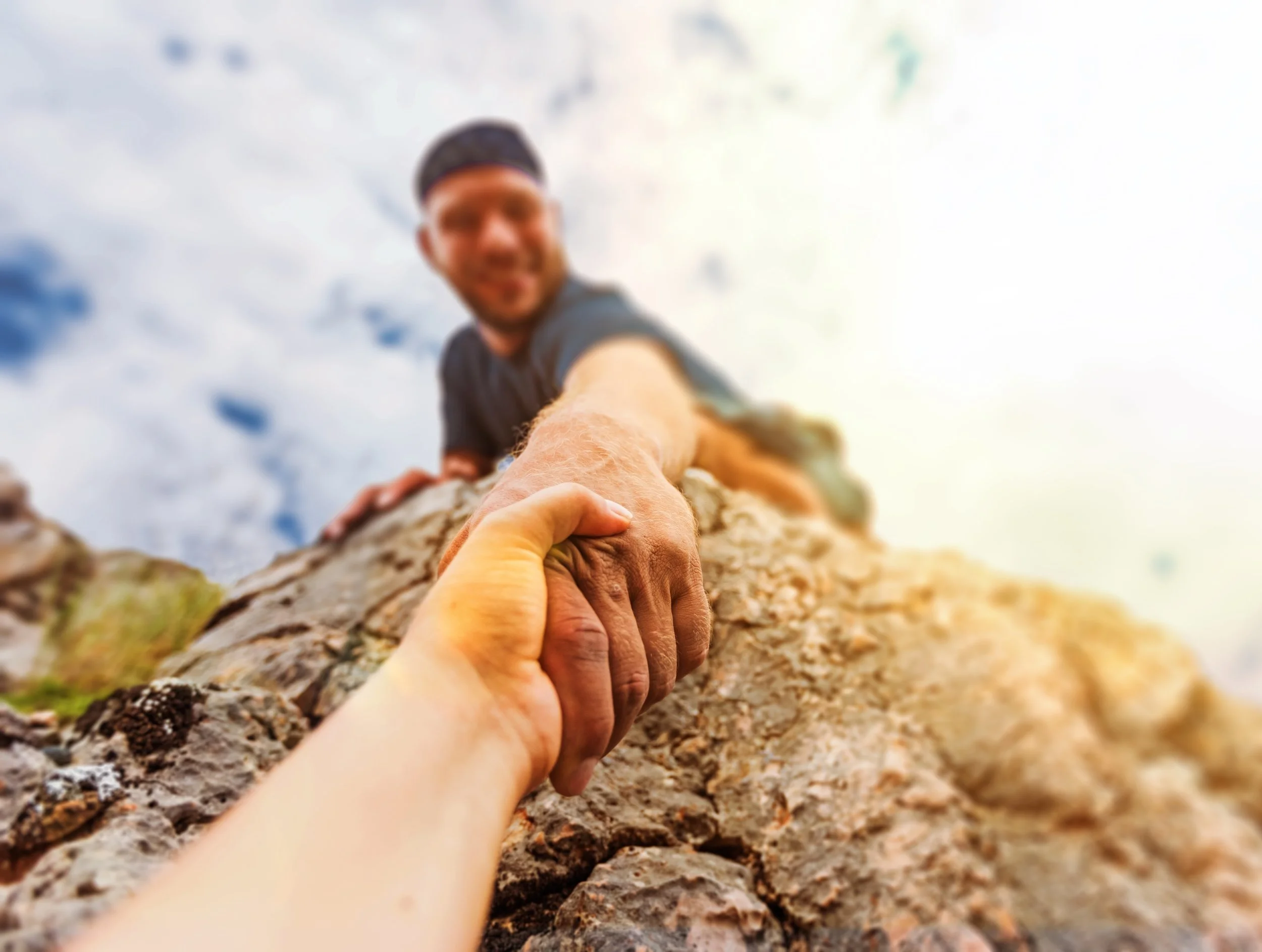 man pulling person up ledge.jpg