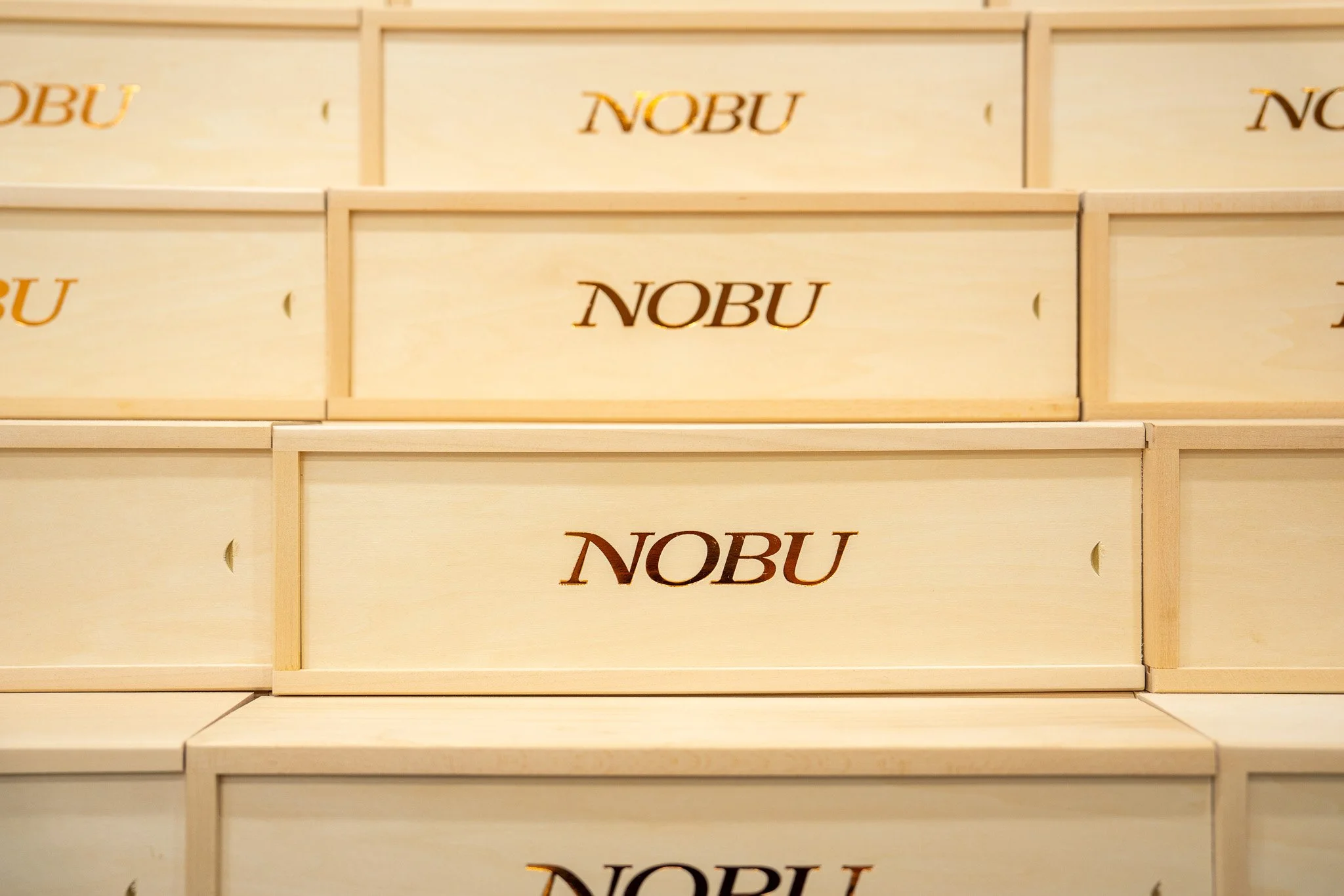 Branded wooden gift boxes in Miami with Nobu logo detail on custom box lids
