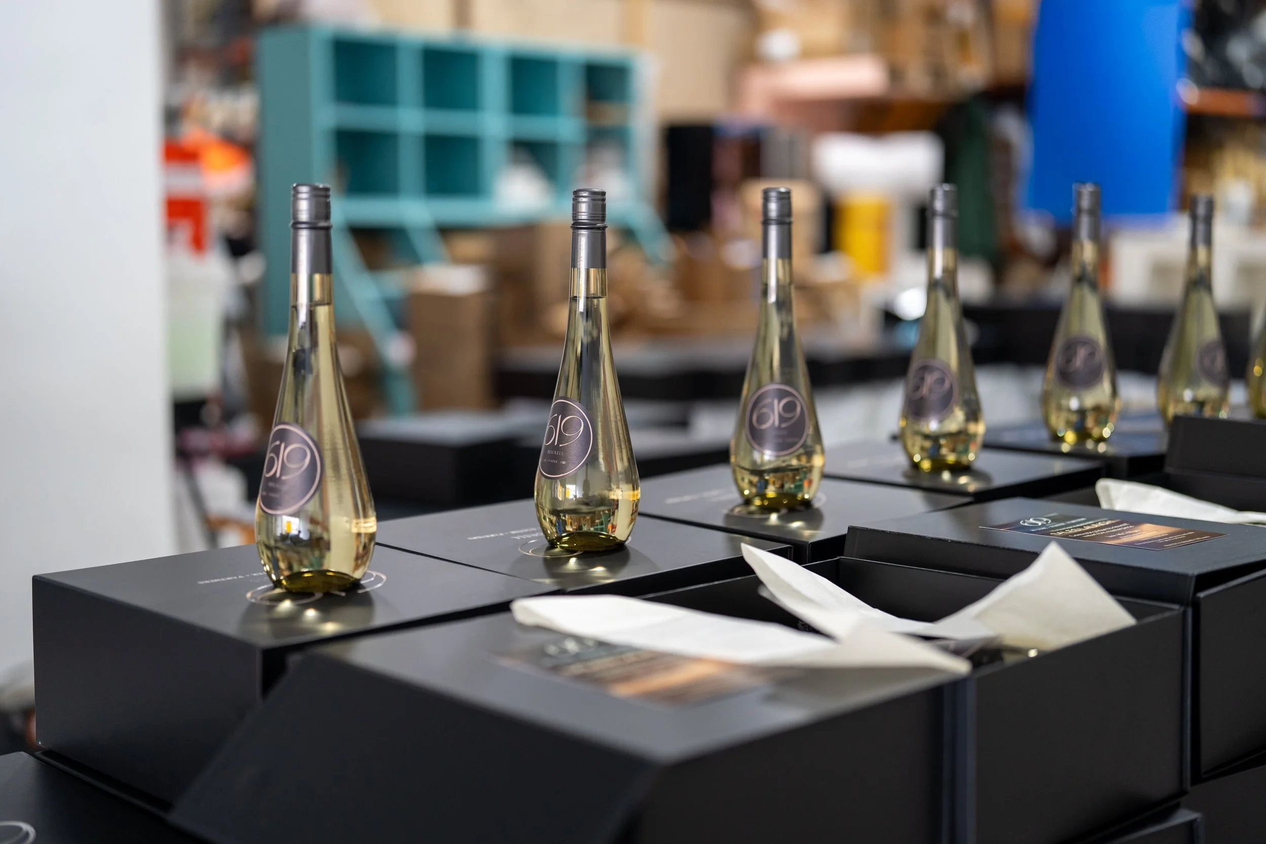 Large order of branded corporate gift boxes in Miami with labeled bottles aligned for assembly